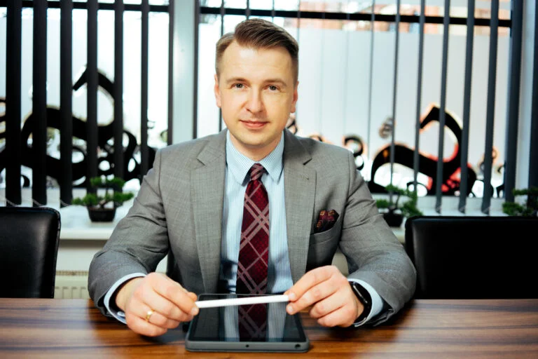 Portret biznesowy mężczyzny w garniturze przy biurku z tabletem