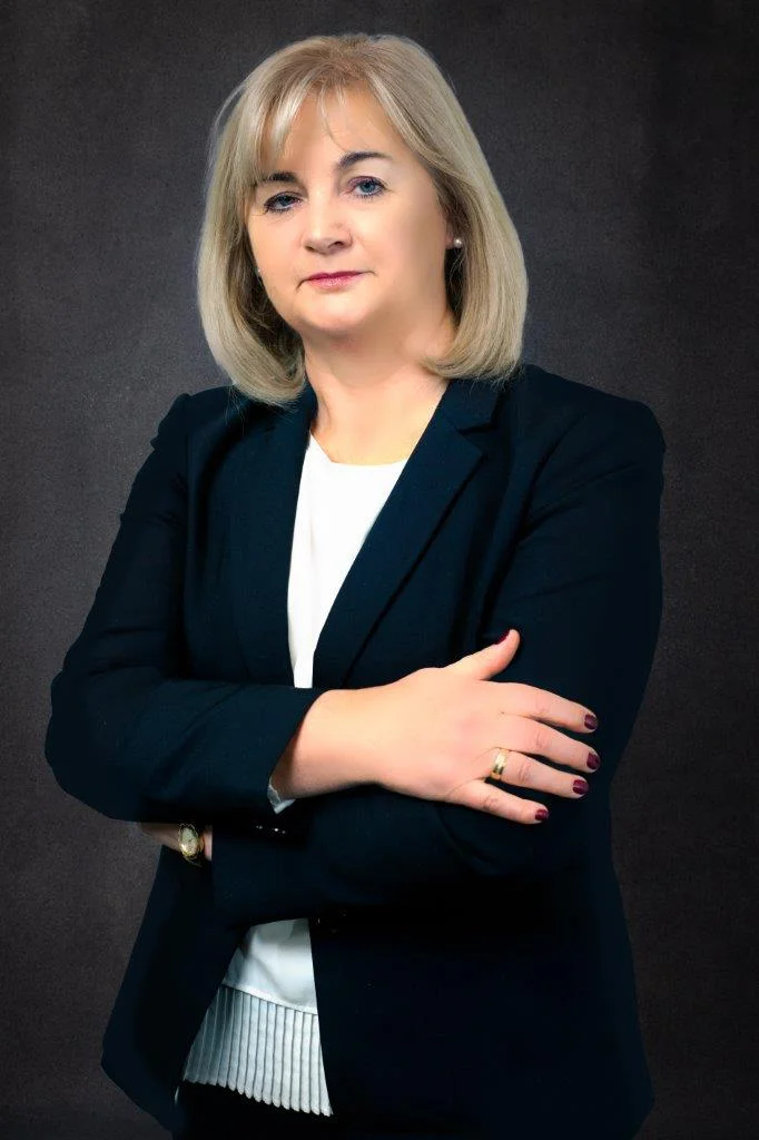 Portret biznesowy kobiety w ciemnej marynarce na ciemnym tle