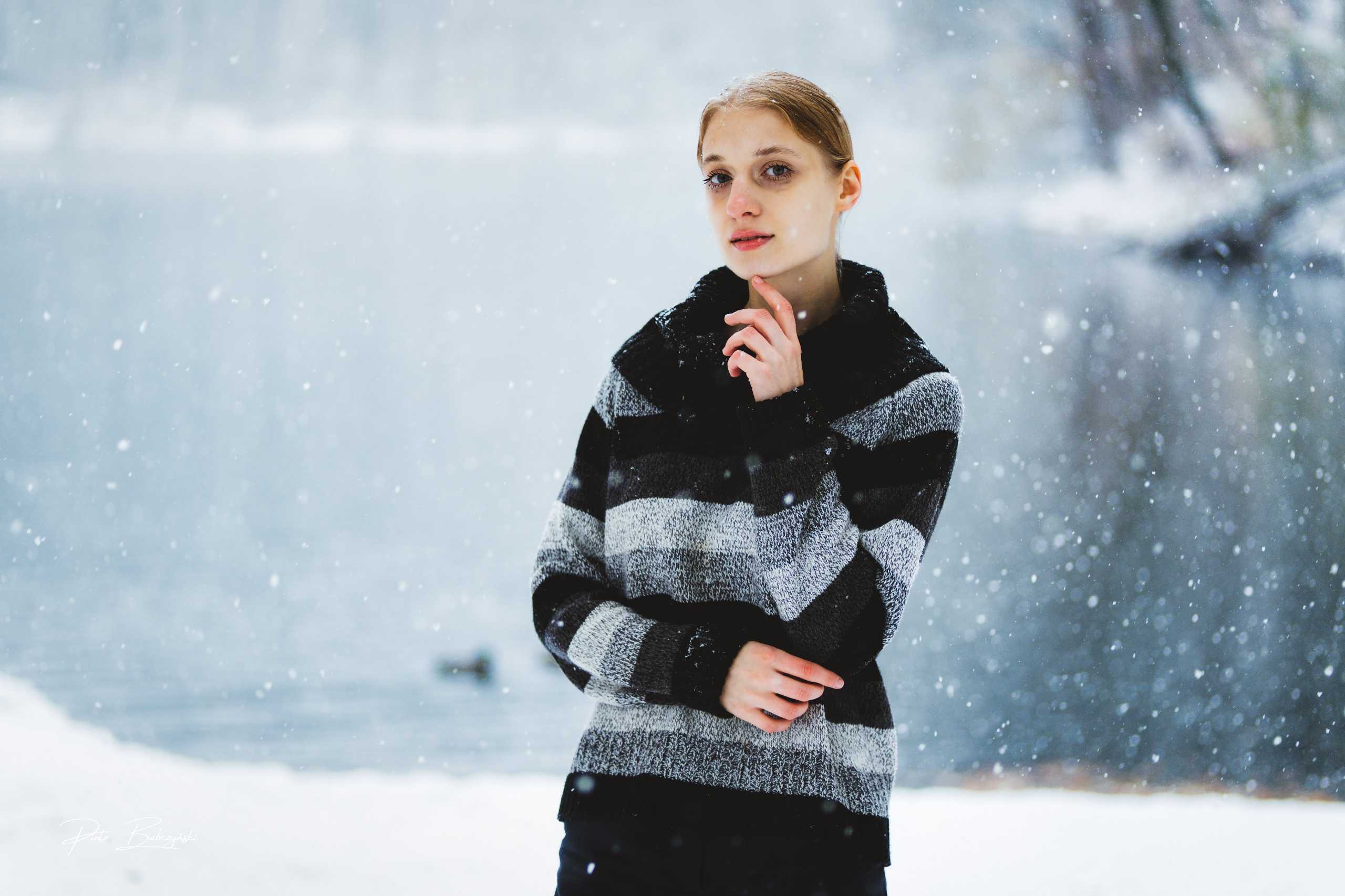 Portret modelki w zimowej scenerii nad Jeziorem Szmaragdowym w Szczecinie, w tle padający śnieg.