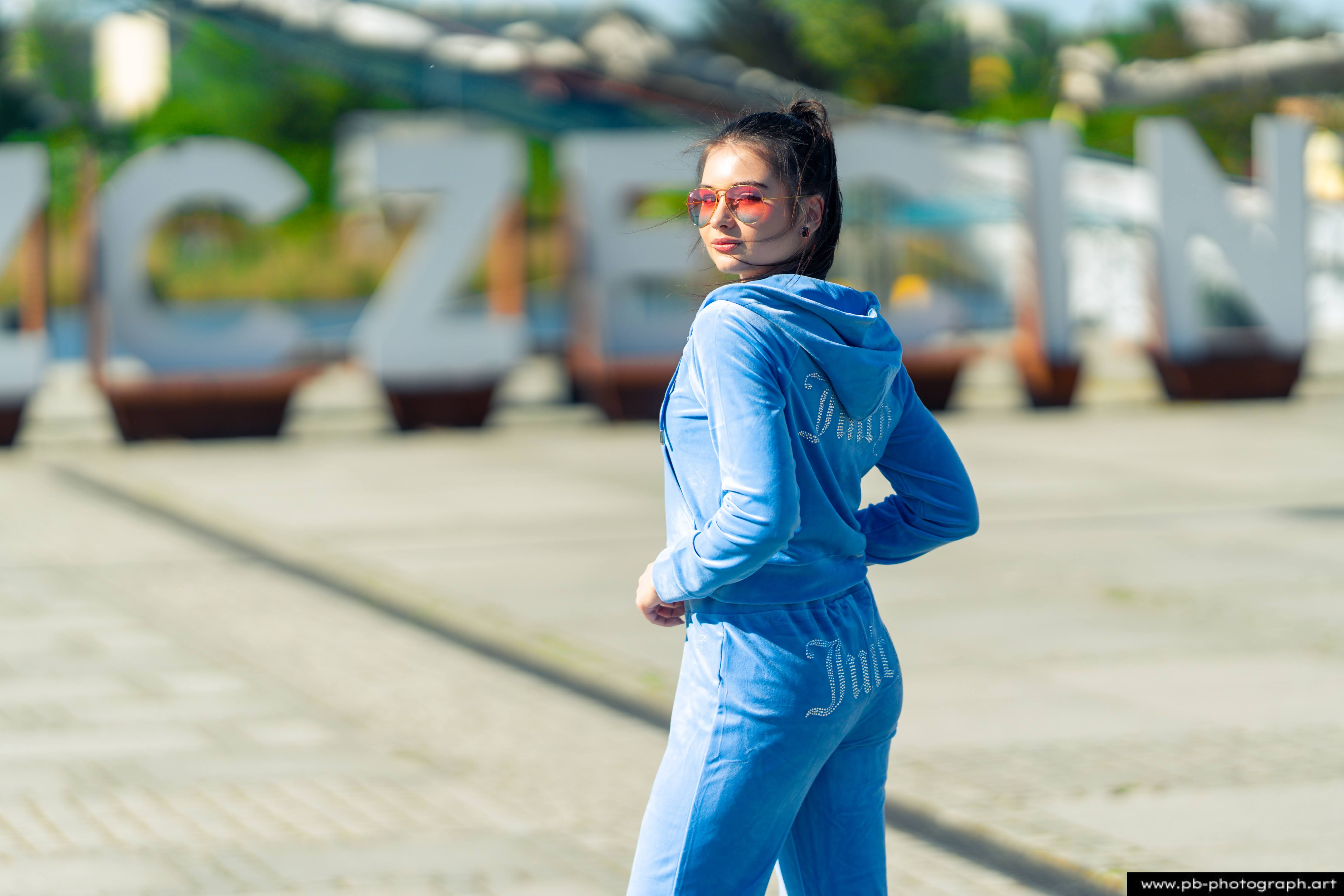 Fotografia produktowa na Łasztowni w Szczecinie — modelka w niebieskim dresie, podkreślająca unikalny styl kolekcji.