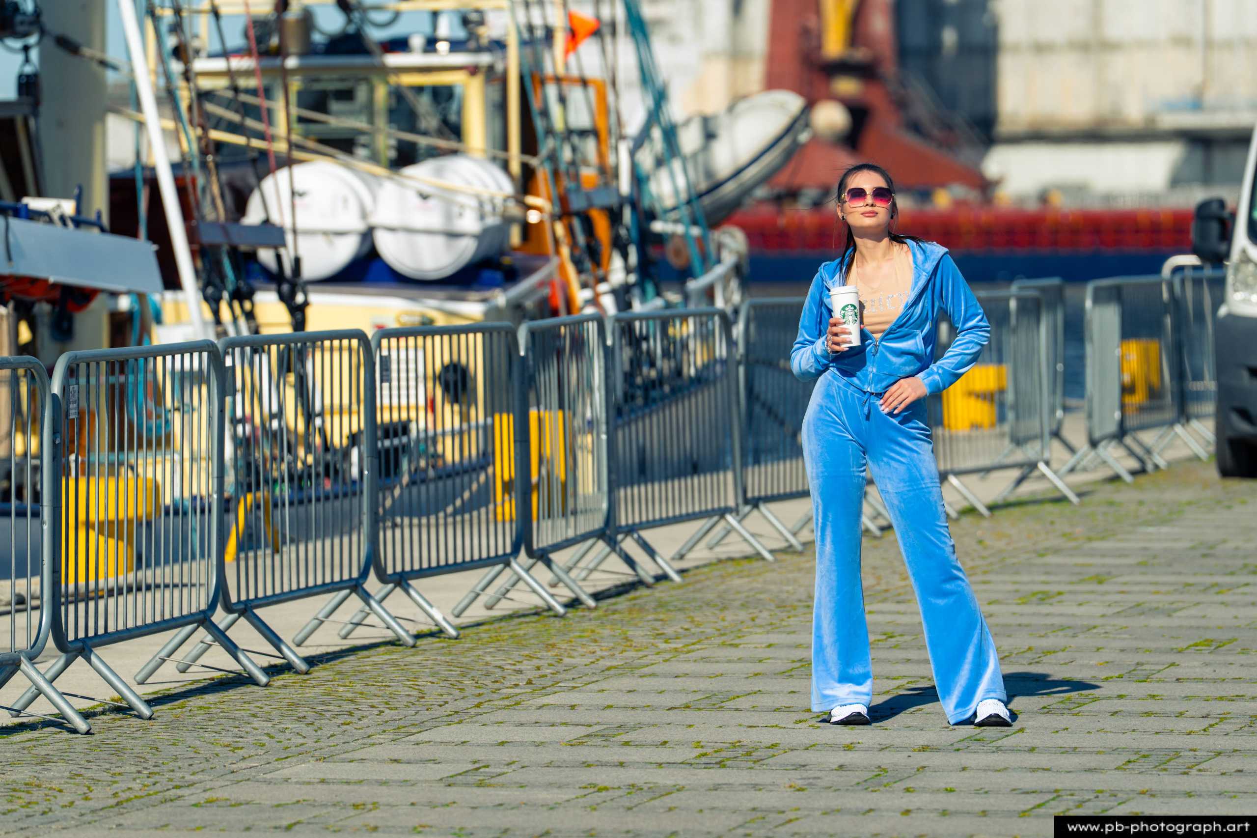 Fotografia produktowa na Łasztowni w Szczecinie — modelka w niebieskim dresie z butelką wody.