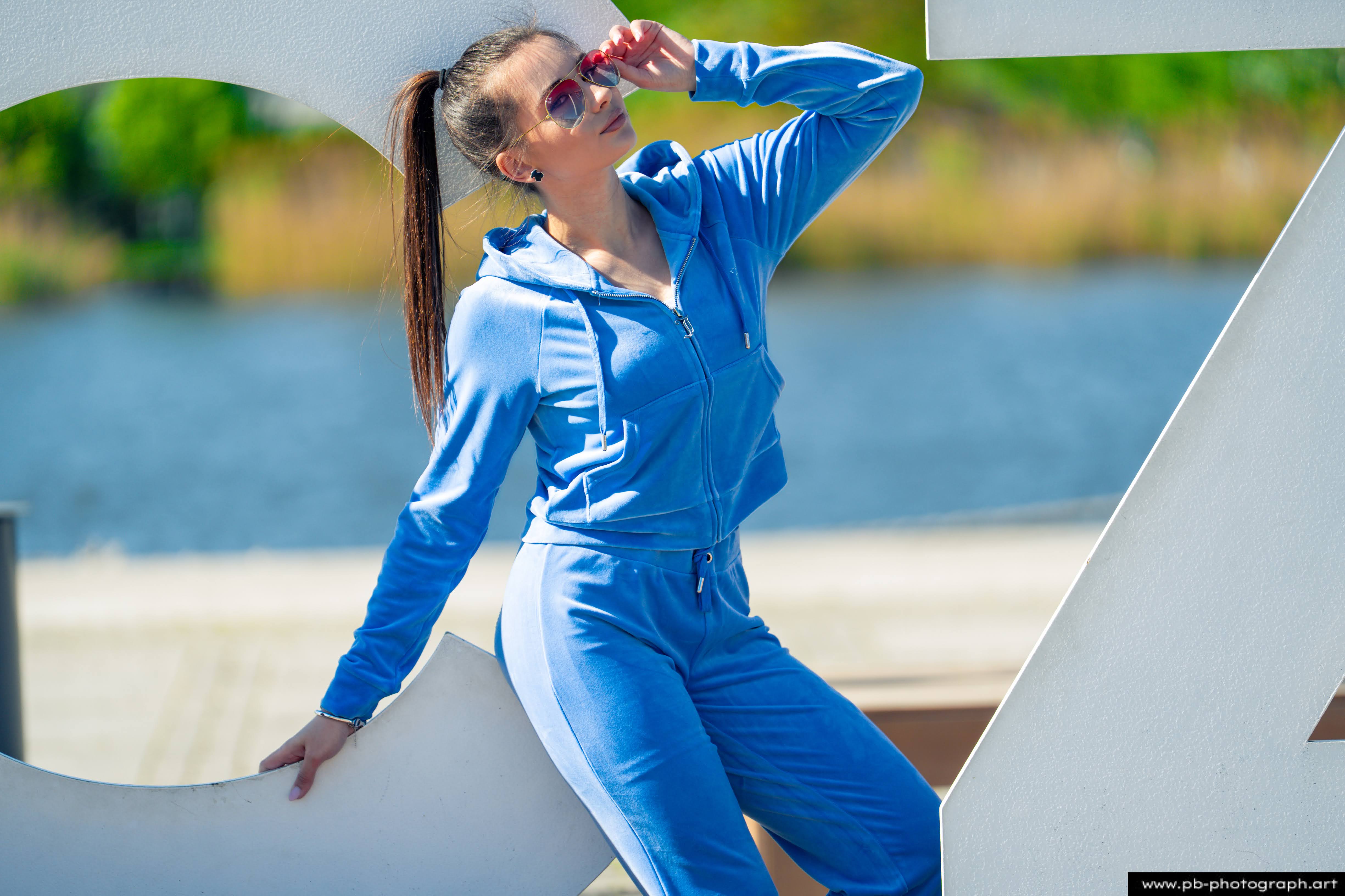 Fotografia produktowa na Łasztowni w Szczecinie — modelka w niebieskim dresie, podkreślająca styl najnowszej kolekcji.