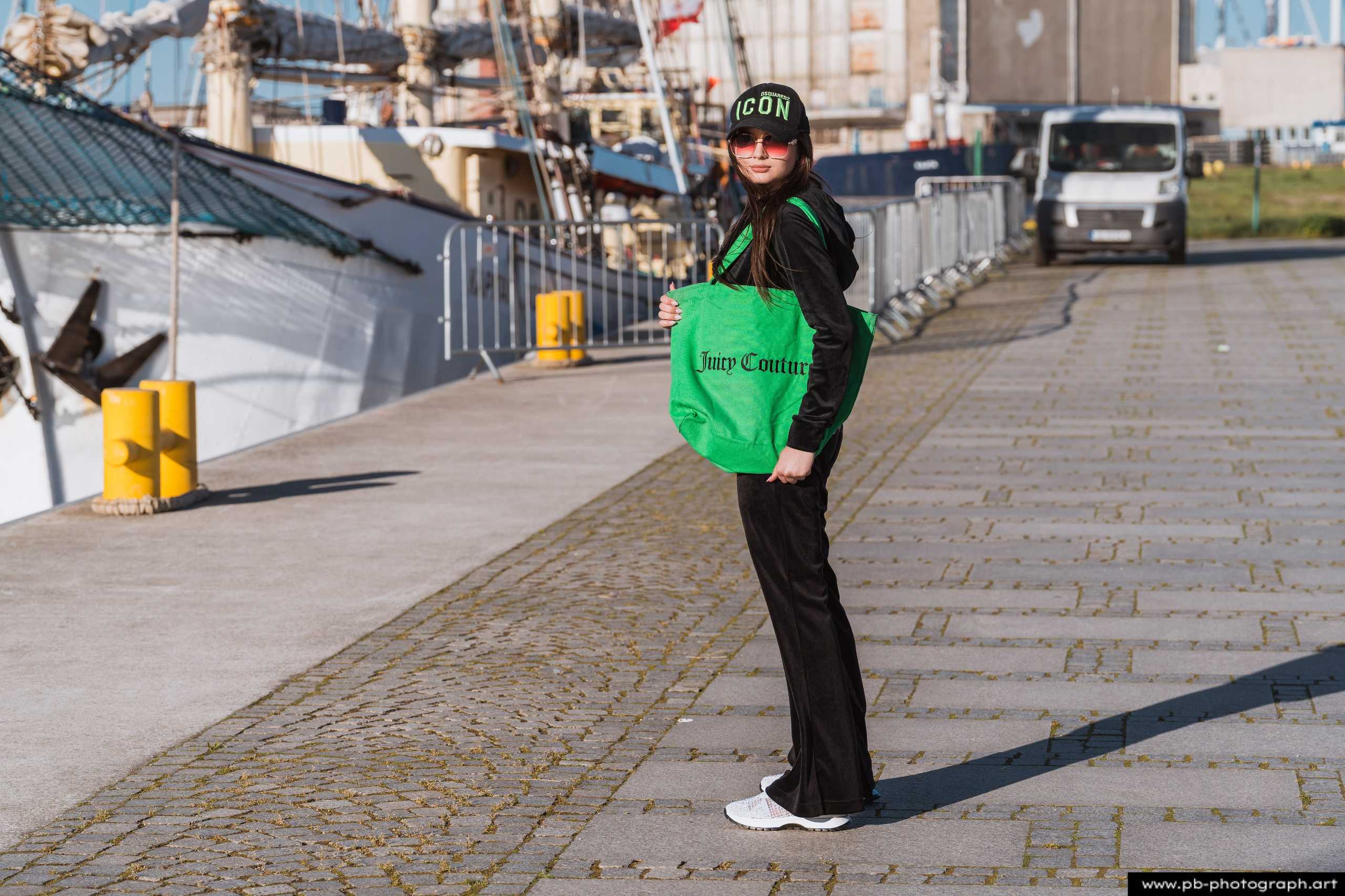 Fotografia produktowa na Łasztowni w Szczecinie — modelka w unikalnej odzieży z torbą marki.
