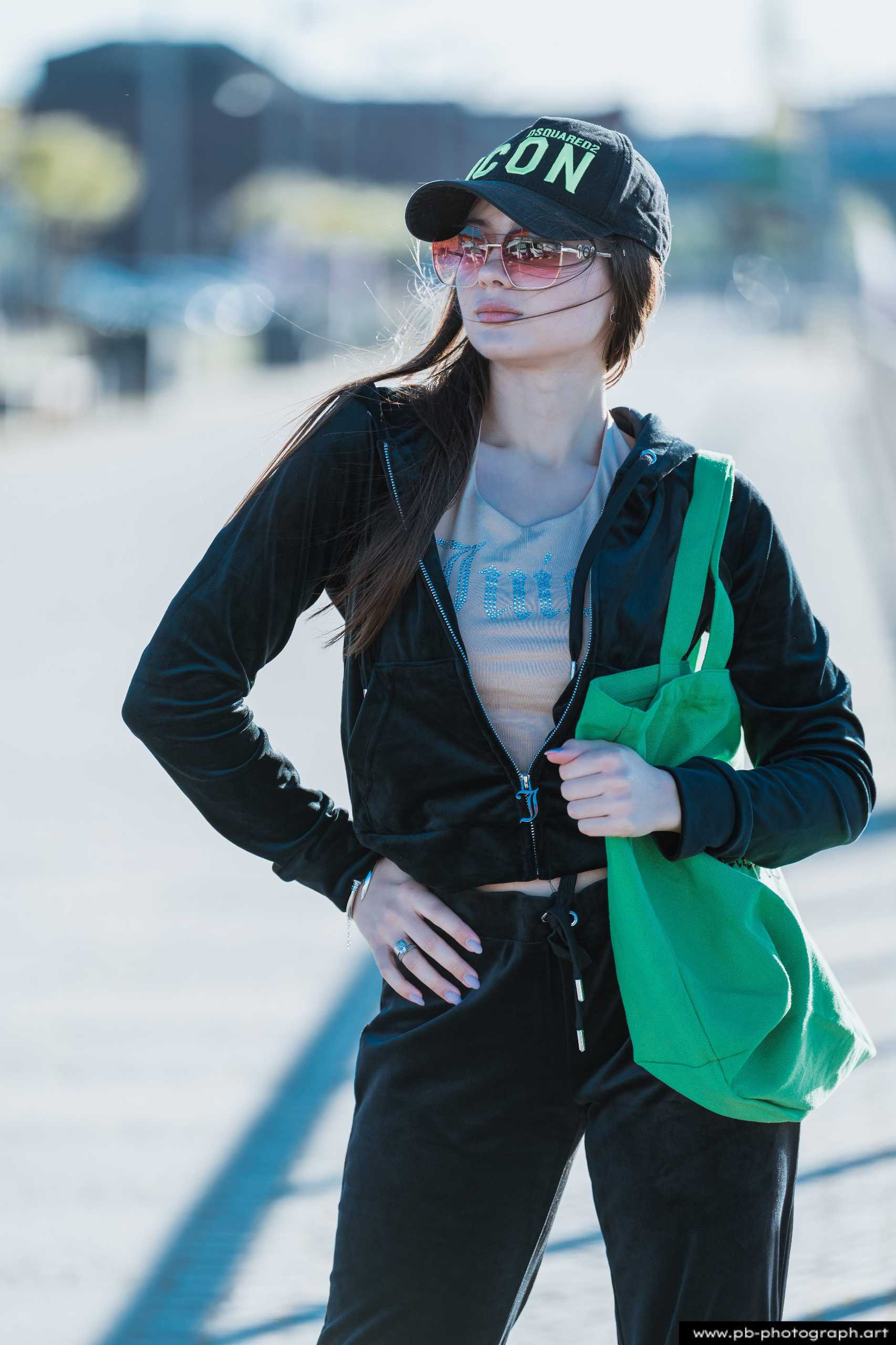 Fotografia produktowa na Łasztowni w Szczecinie — modelka w odzieży sportowej z zieloną torbą.