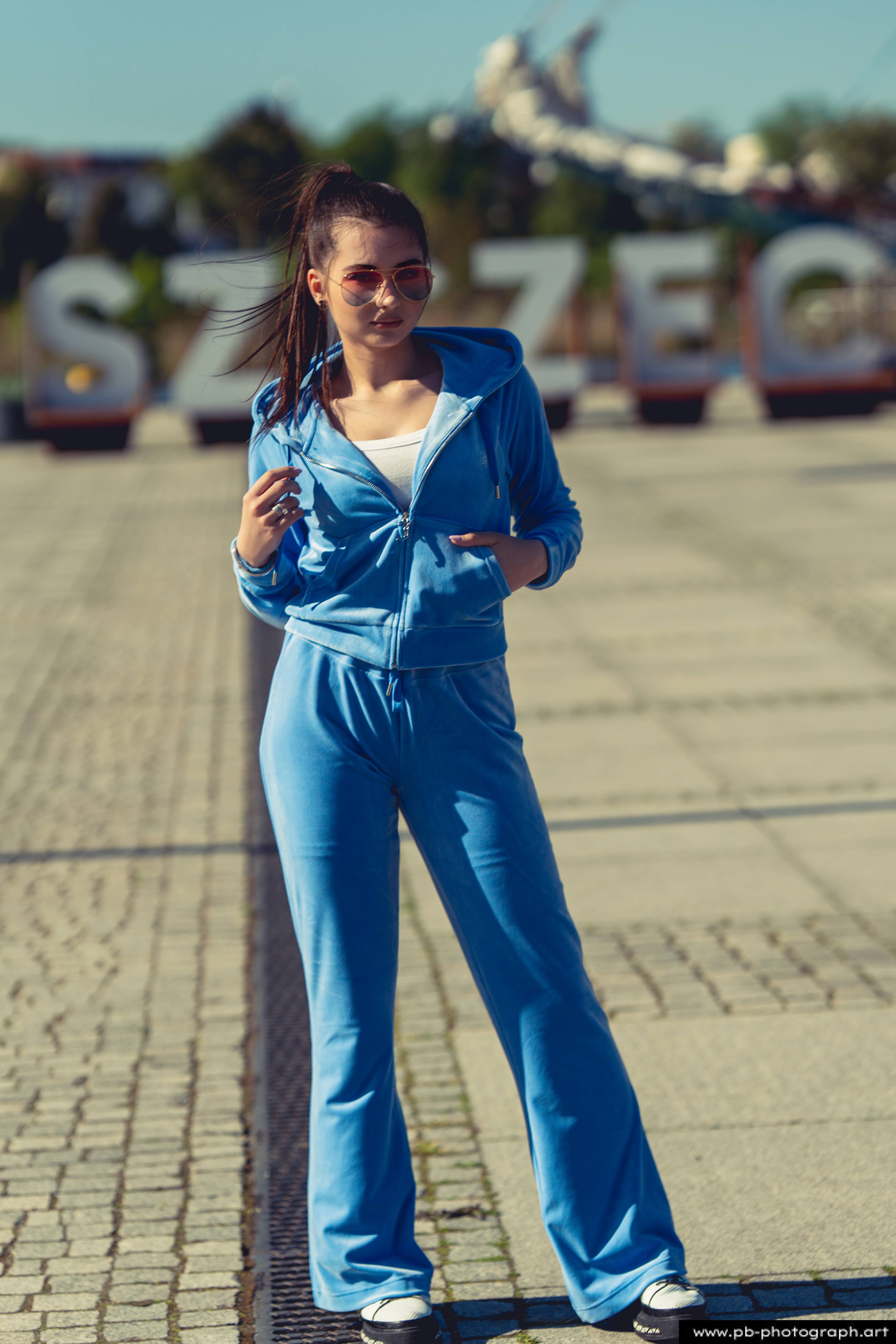 Fotografia produktowa na Łasztowni w Szczecinie — modelka w niebieskim dresie prezentująca najnowszą kolekcję ubrań.