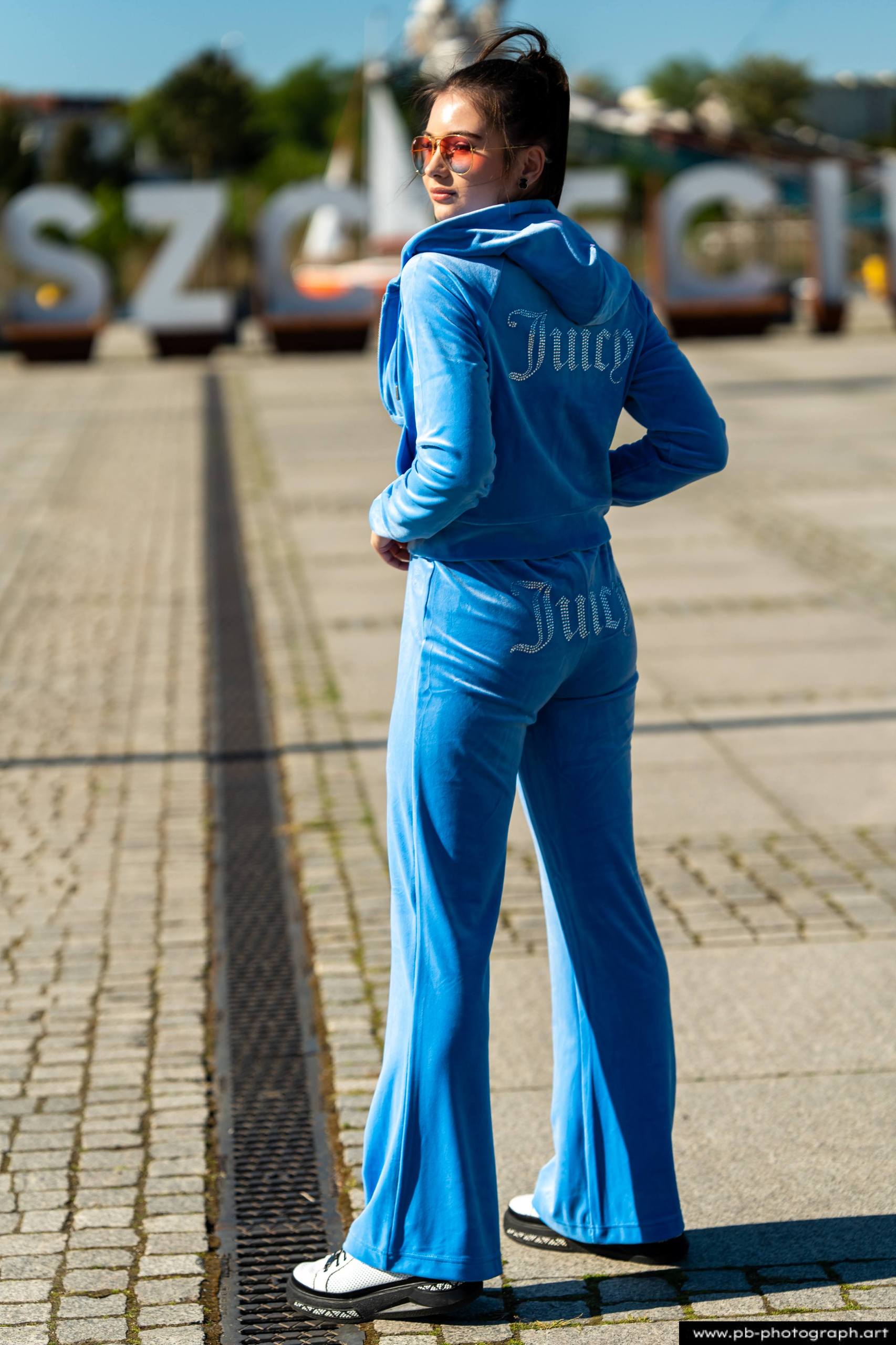 Fotografia produktowa na Łasztowni w Szczecinie — modelka w niebieskim dresie marki odzieżowej.