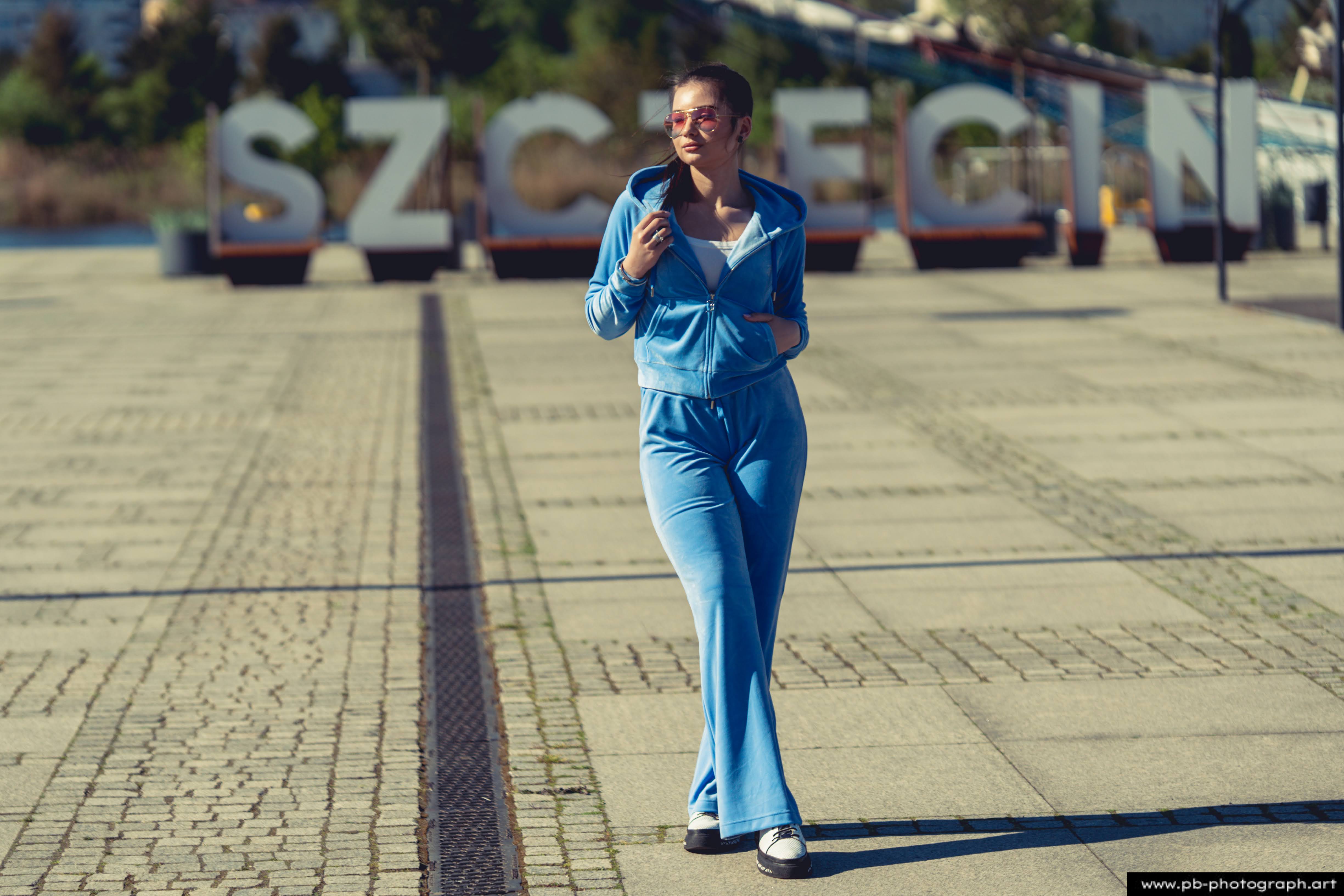 Fotografia produktowa na Łasztowni w Szczecinie — modelka w niebieskim dresie prezentuje najnowszą kolekcję ubrań.
