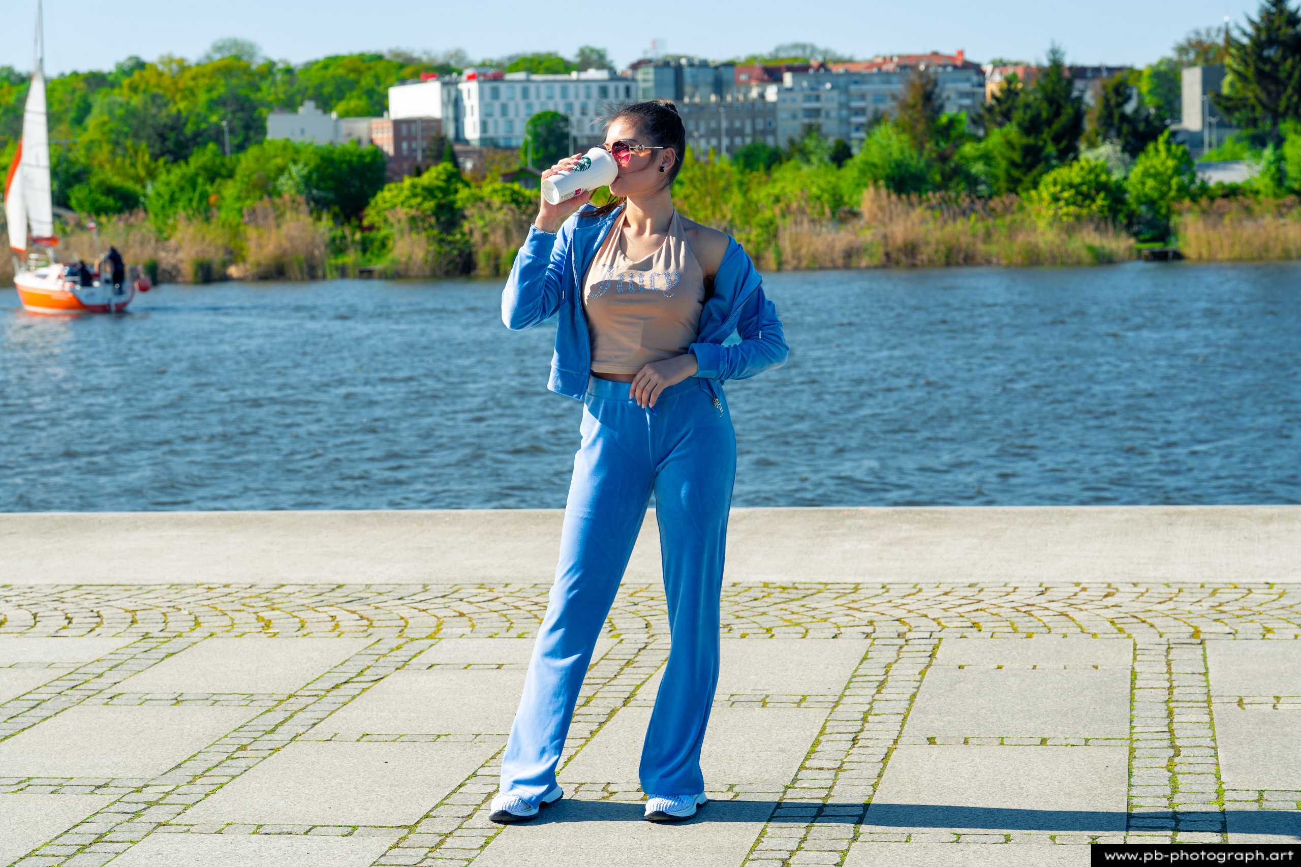 Fotografia produktowa na Łasztowni w Szczecinie — modelka w niebieskim komplecie ubraniowym przy wodzie.