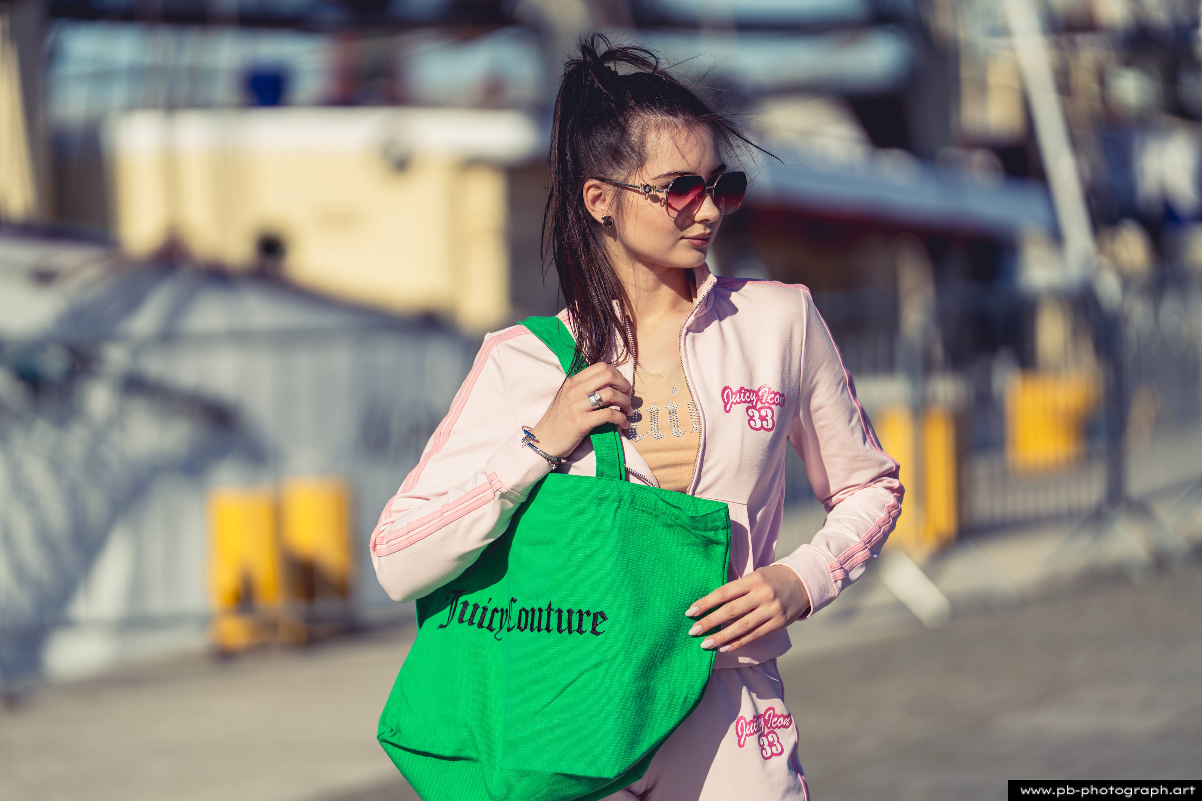 Fotografia produktowa na Łasztowni w Szczecinie — modelka w odzieży marki Juicouture z torbą.