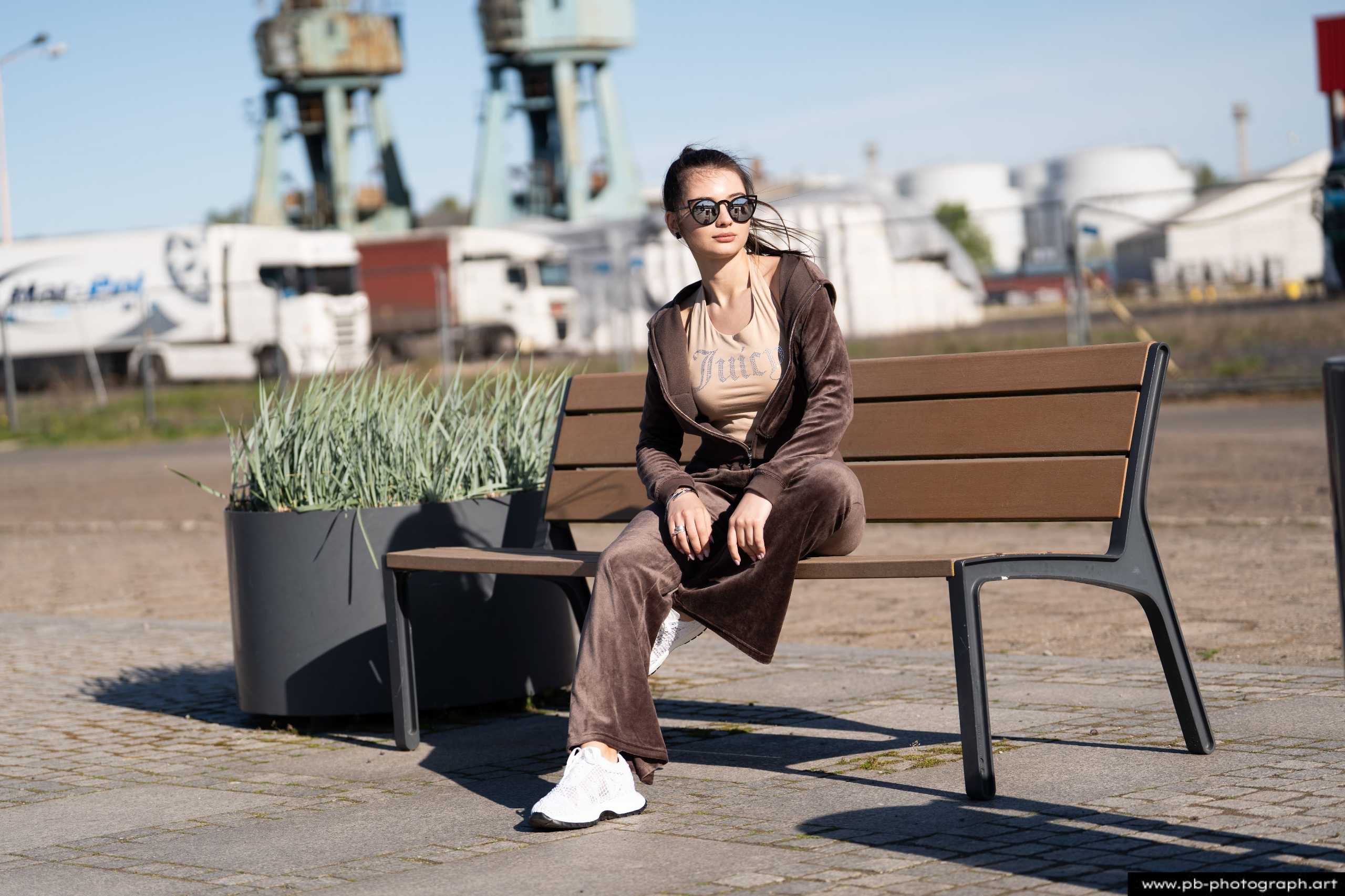 Fotografia produktowa na Łasztowni w Szczecinie — modelka w najnowszej kolekcji odzieży na ławce.