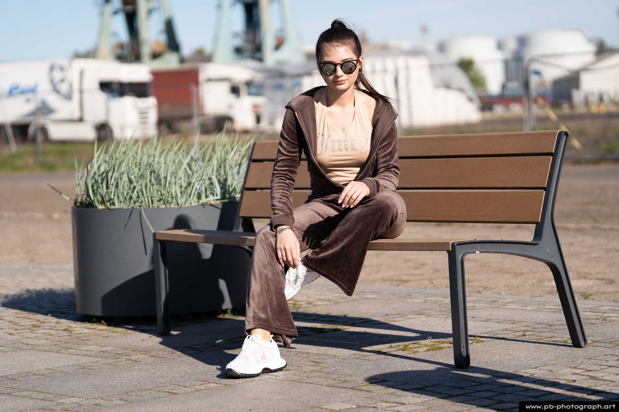 Fotografia produktowa na Łasztowni w Szczecinie — modelka w modnej odzieży sportowej na ławce.