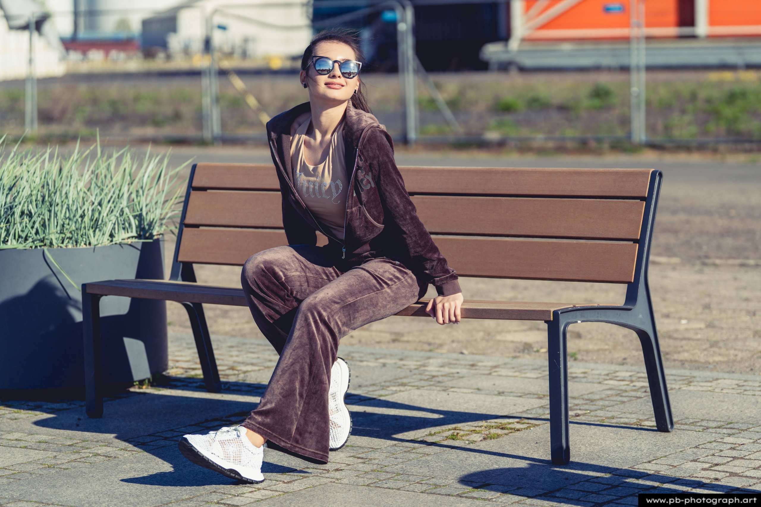 Fotografia produktowa na Łasztowni w Szczecinie — modelka w najnowszej kolekcji odzieży na ławce.