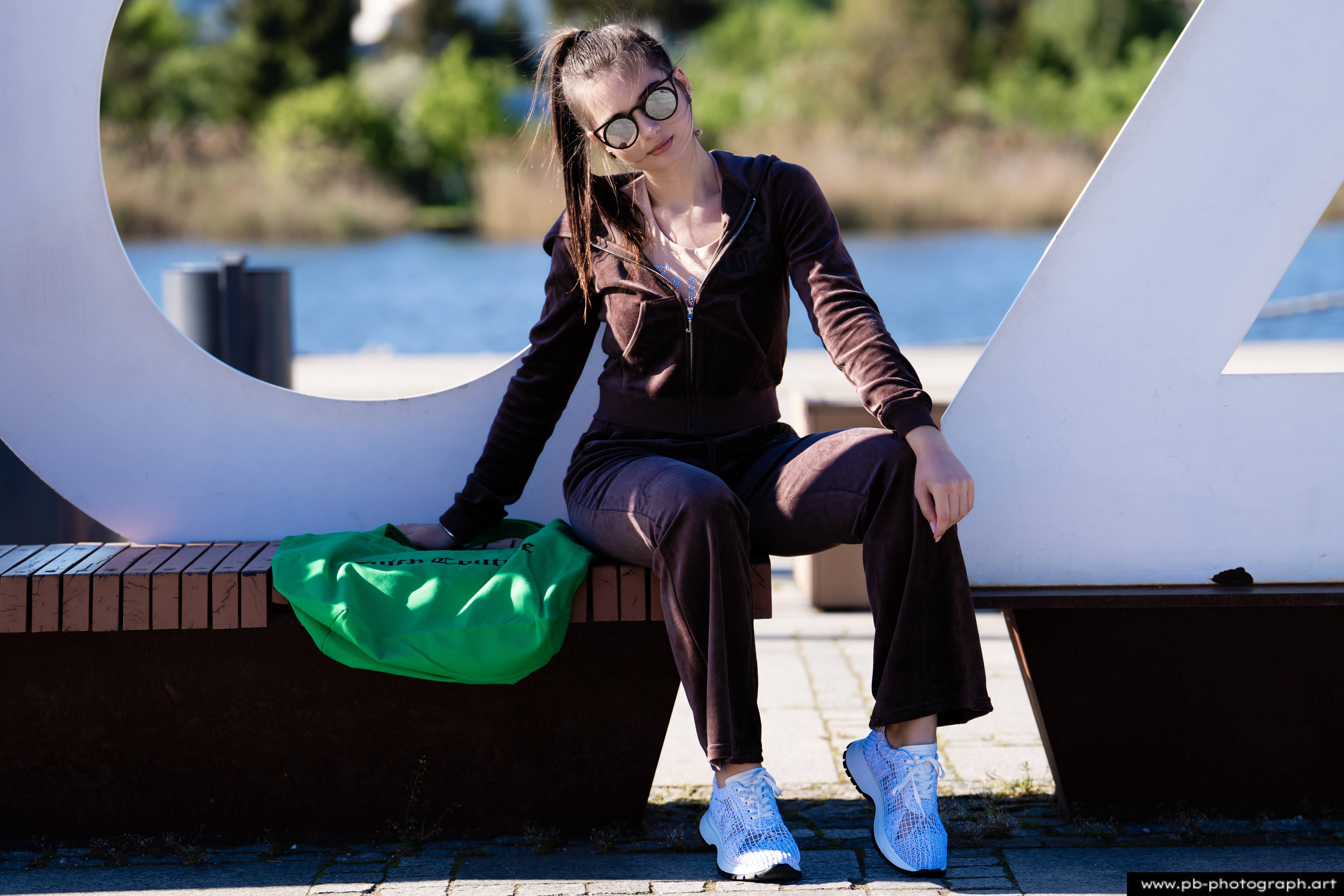 Fotografia produktowa na Łasztowni w Szczecinie — modelka w unikalnej kolekcji odzieży z torbą.