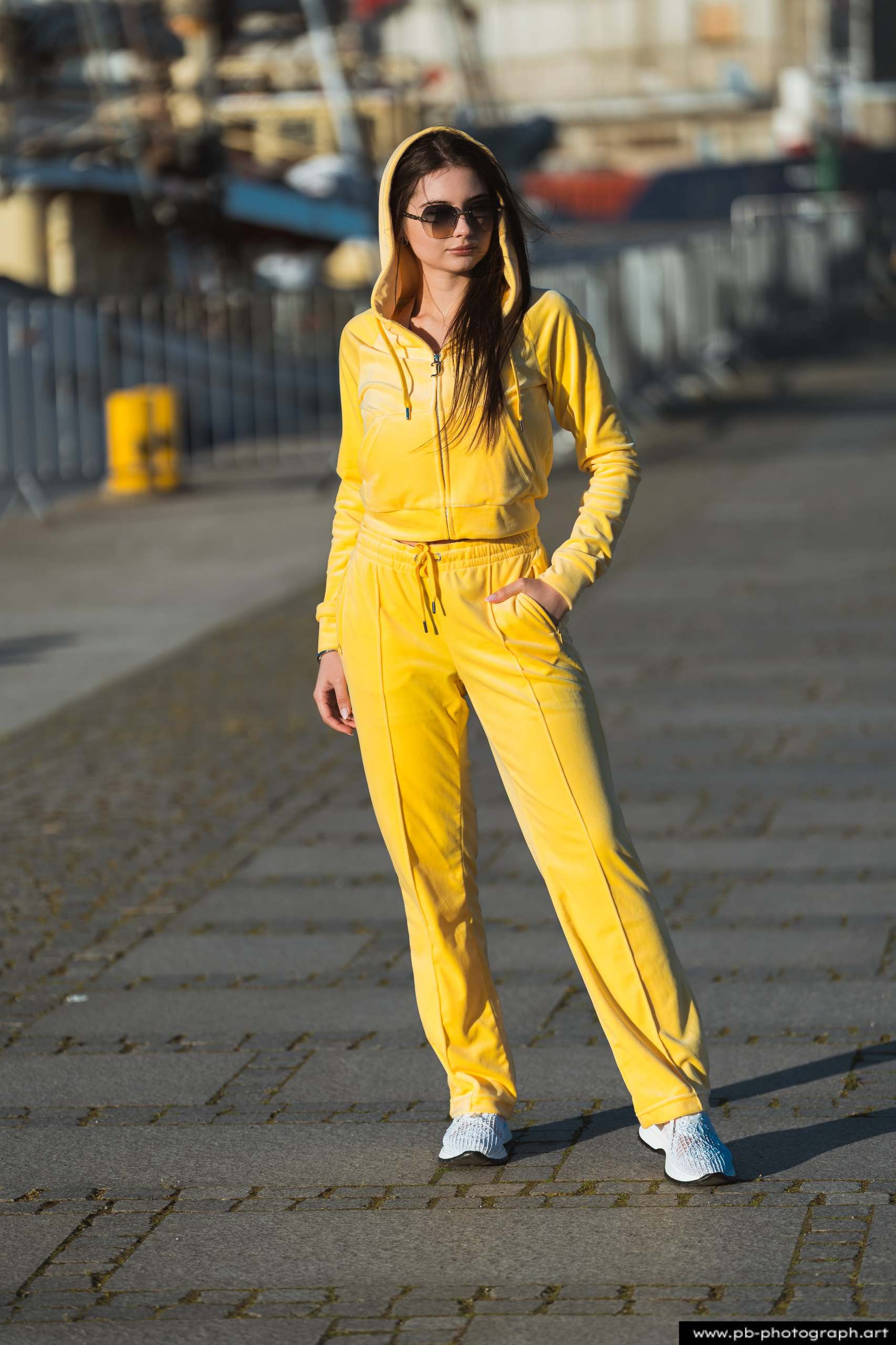 Fotografia produktowa na Łasztowni w Szczecinie — modelka w żółtym dresie prezentująca najnowszą kolekcję ubrań.
