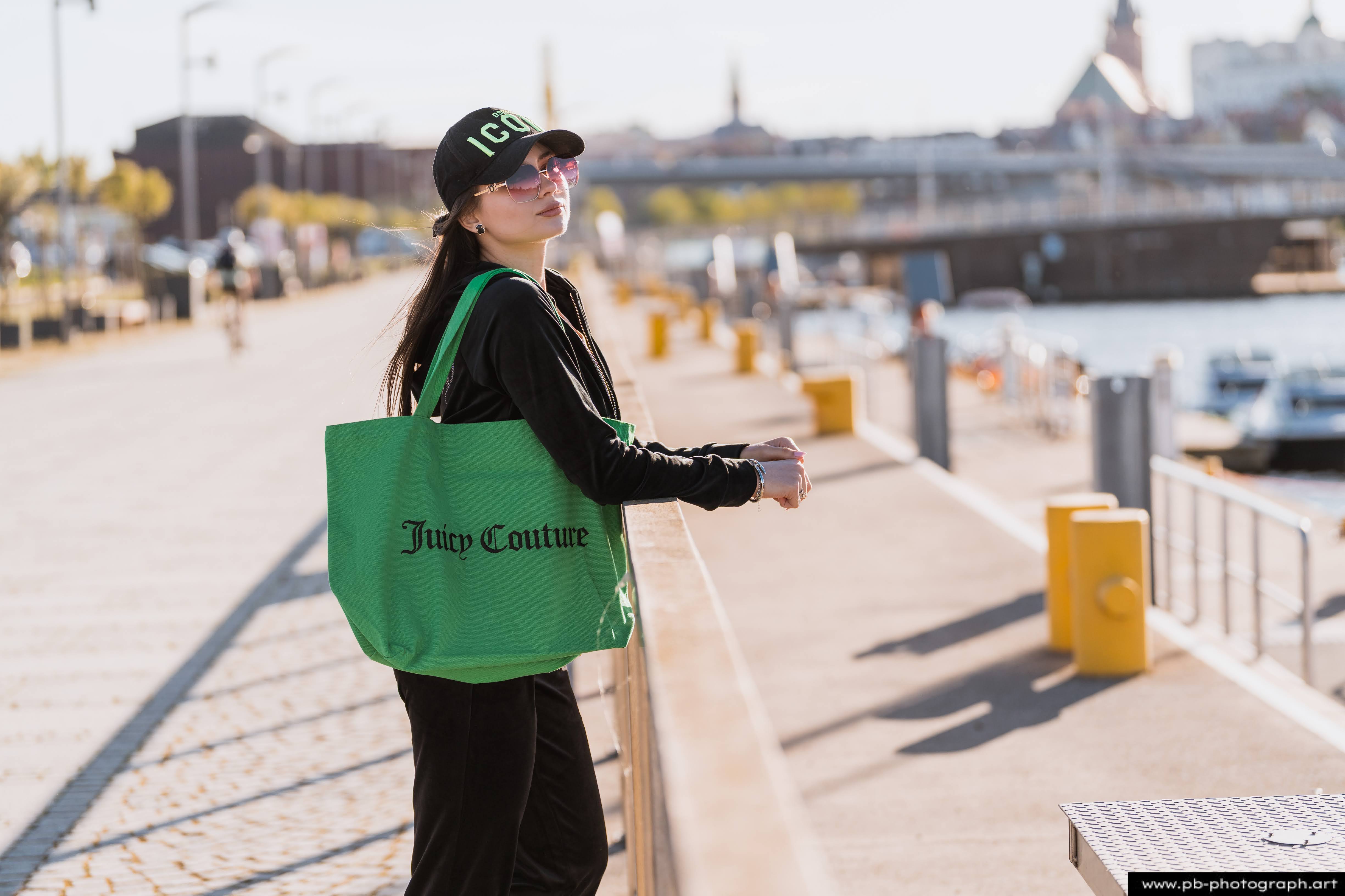 Fotografia produktowa na Łasztowni w Szczecinie — modelka z torbą Juicy Couture w unikalnym stylu.