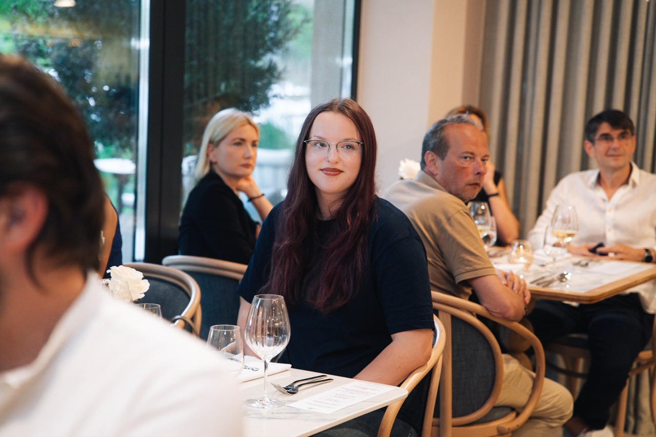 Fotografia eventowa z kolacji degustacyjnej z Karolem Okrasą w luksusowym hotelu w Szczecinie — goście przy stole.