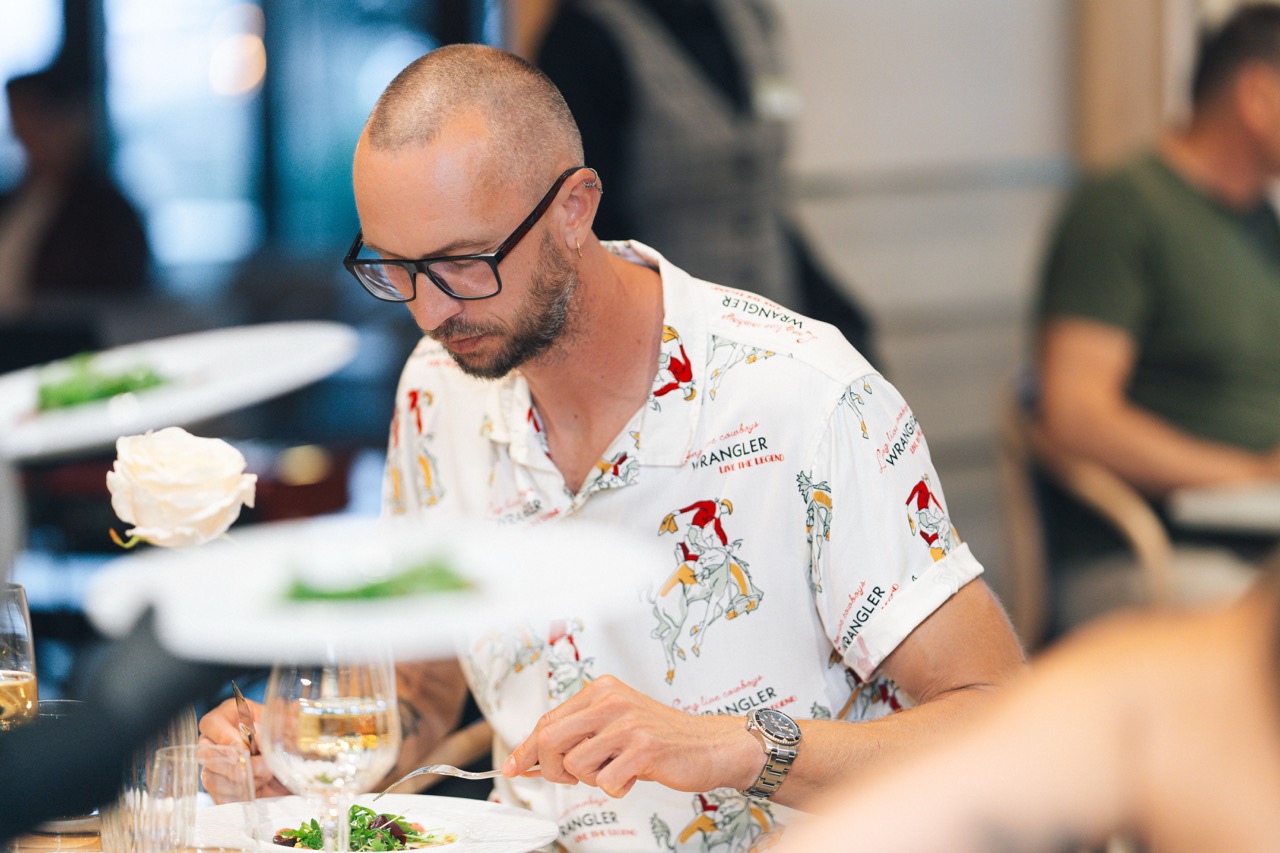 Fotografia eventowa z kolacji degustacyjnej z Karolem Okrasą w luksusowym hotelu w Szczecinie — gość delektujący się daniem.