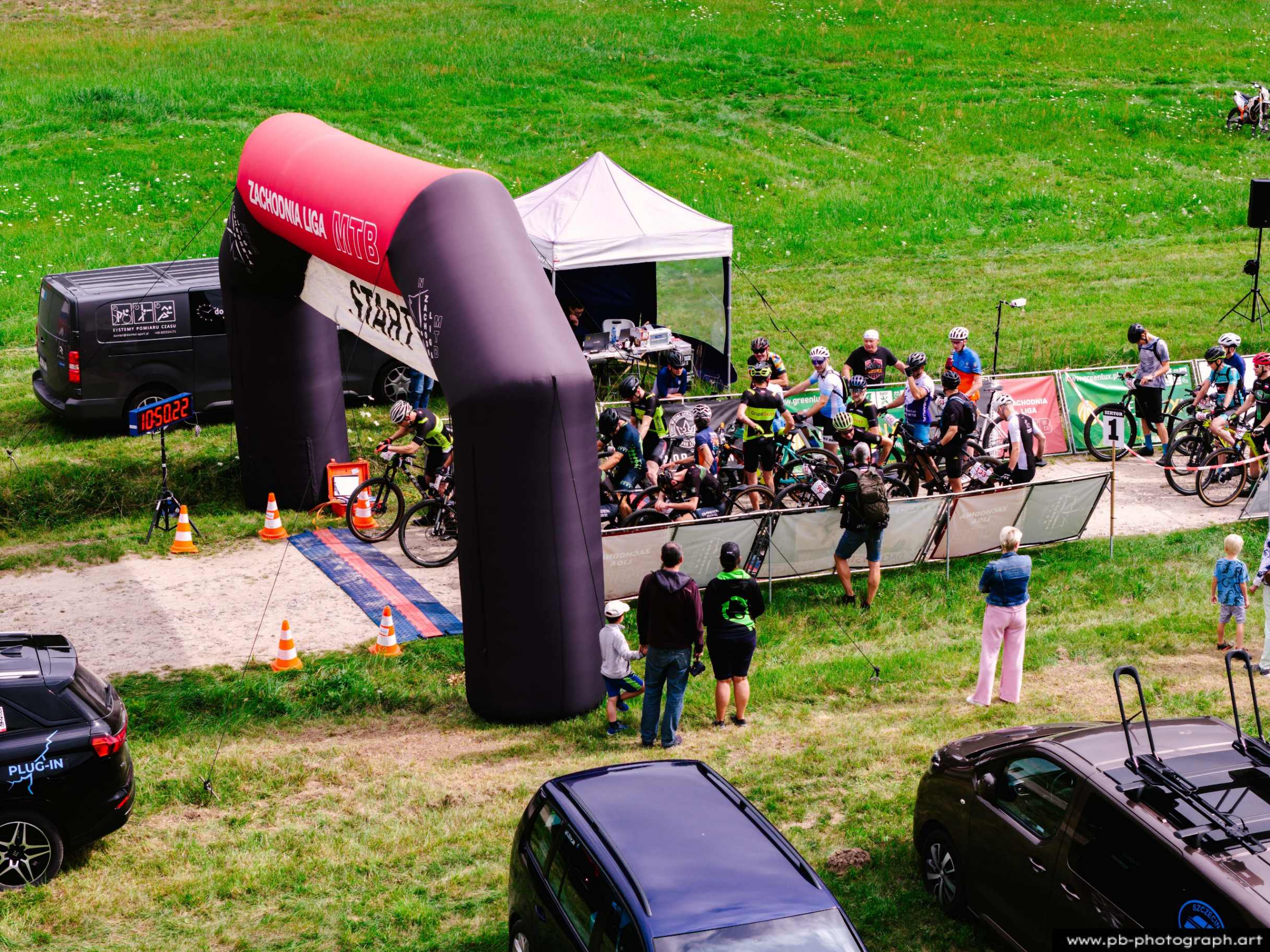 Ujęcie z drona na start wyścigu MTB w Szczecinie, z zawodnikami przygotowującymi się do startu pod balonem startowym.