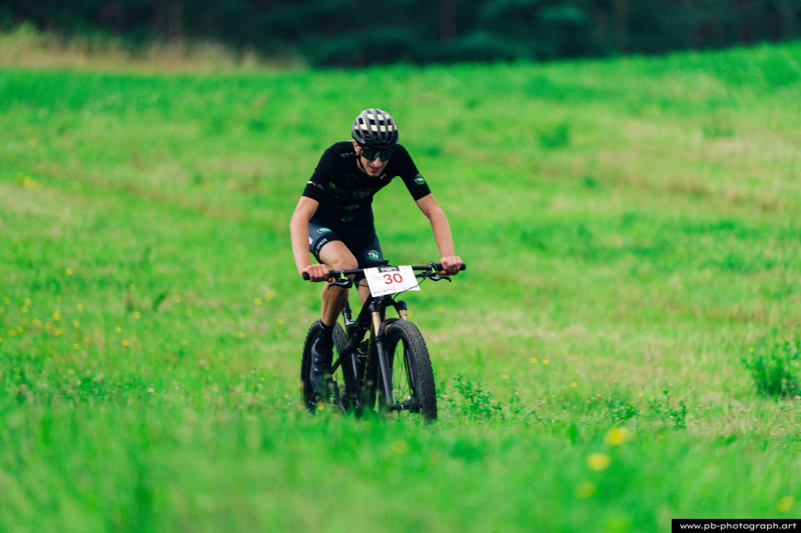 Ujęcie z drona zawodnika MTB na zielonym tle trasy wyścigu podczas Rajdu MTD w Szczecinie.