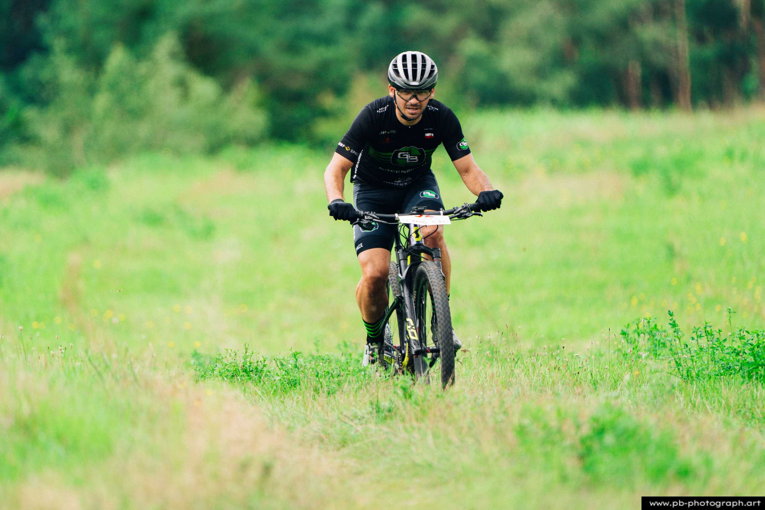 Fotografia z drona podczas Rajdu MTD — zawodnik MTB pokonujący trasę w zielonym terenie w Szczecinie.