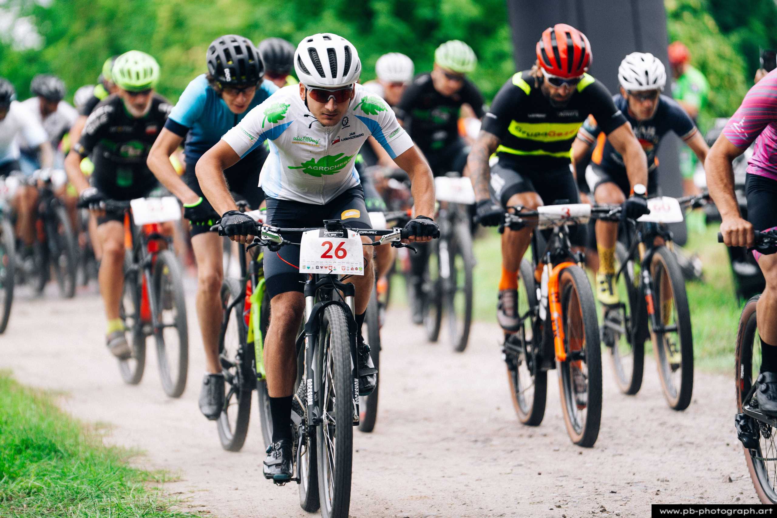 Ujęcie z drona na zawodników MTB w trakcie wyścigu w Szczecinie, z bliska na trasie, z intensywnym ruchem kolarzy.