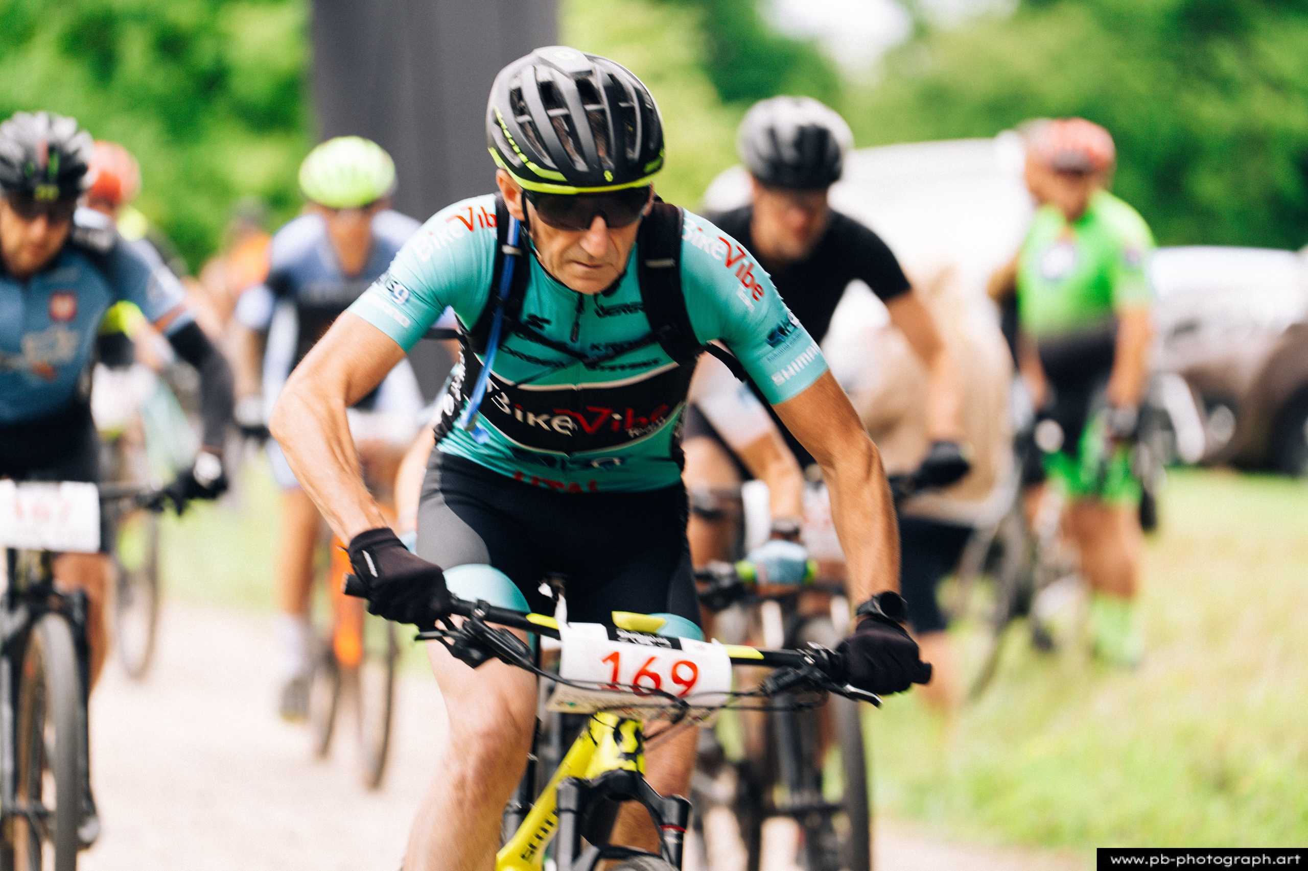 Zawodnik na rowerze górskim w trakcie wyścigu MTB, z numerem startowym 169, na trasie w Szczecinie.