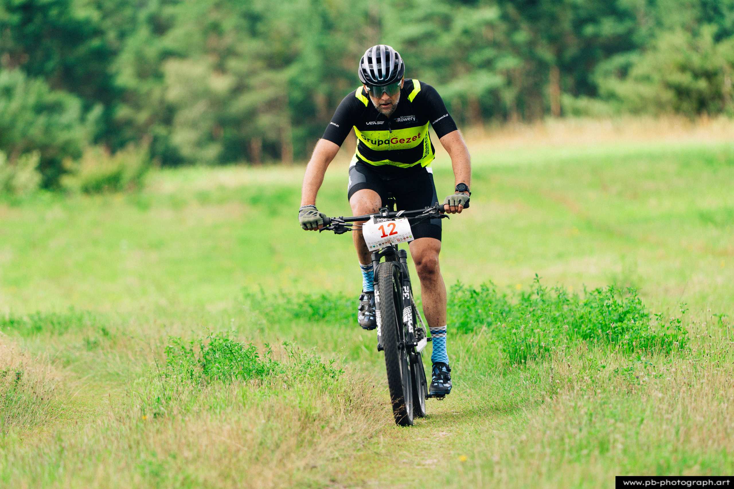 Fotografia z drona przedstawiająca zawodnika MTB na trasie wyścigu w Szczecinie, zbliżenie na rowerzystę w akcji.