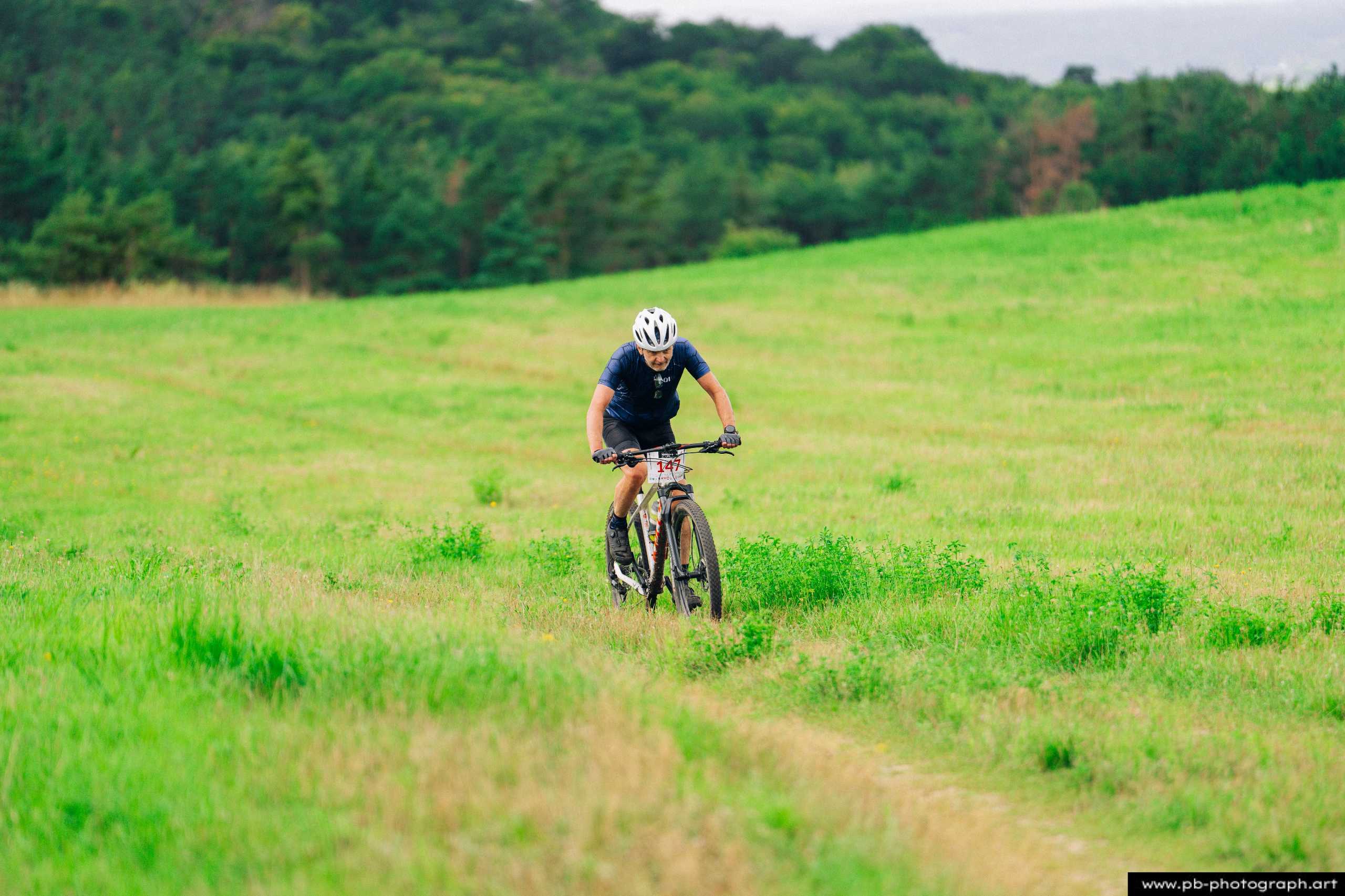 Fotografia z drona ukazująca zawodnika MTB pokonującego zieloną trasę w Szczecinie.