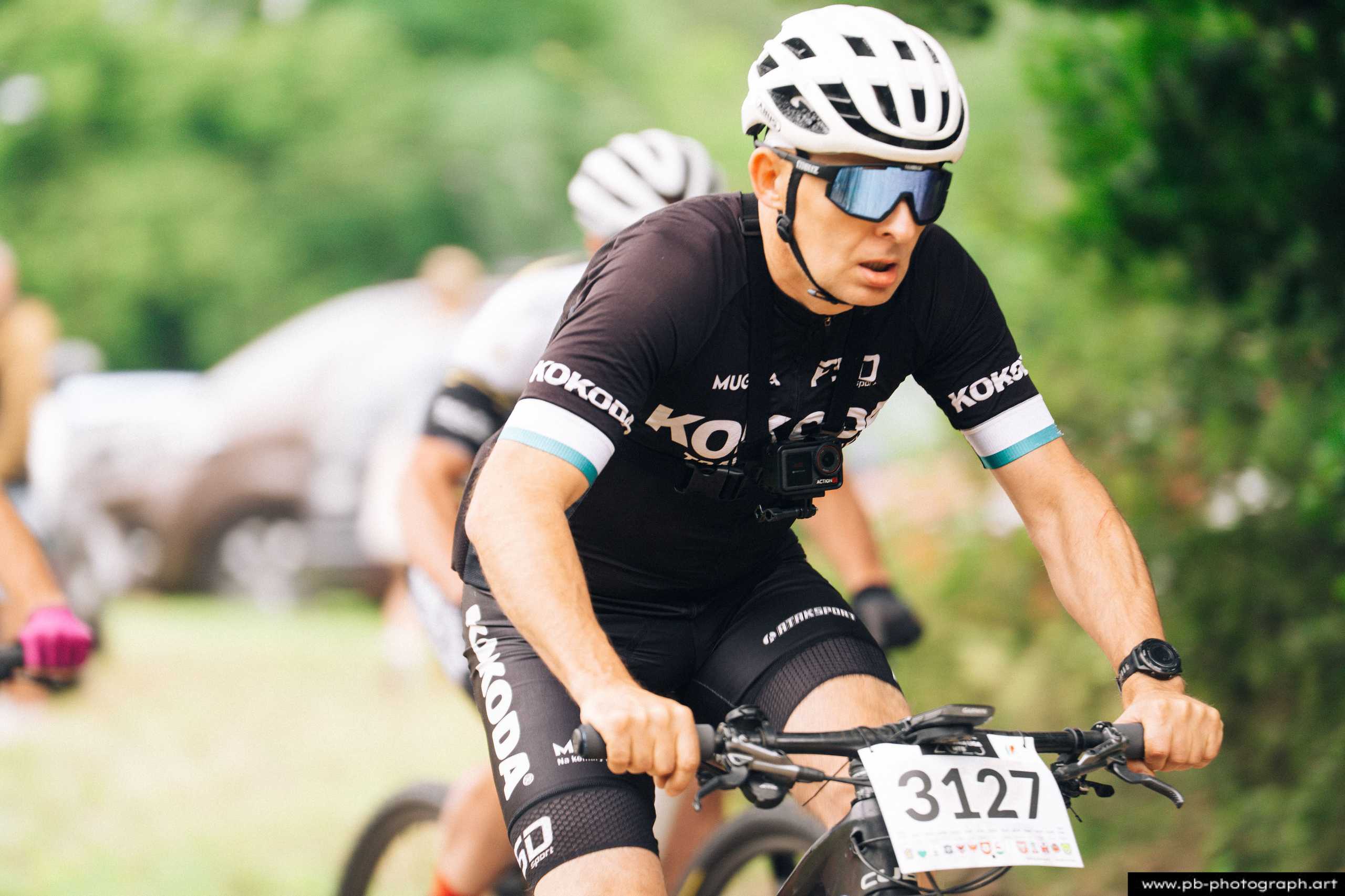 Zawodnik w koszulce z numerem 3127 na trasie wyścigu MTB, dynamiczne ujęcie z bliska w Szczecinie.