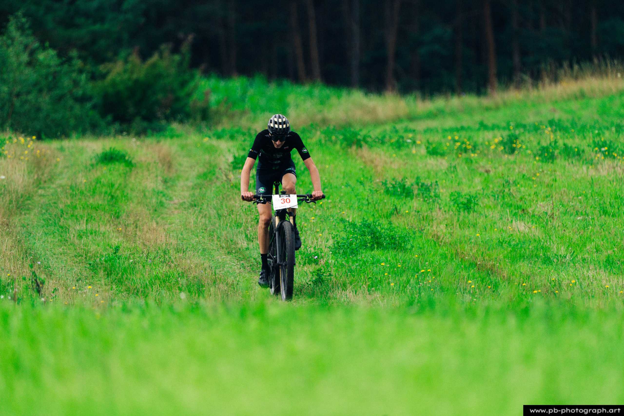 Ujęcie z drona zawodnika MTB podczas wyścigu na zielonym terenie w Szczecinie.