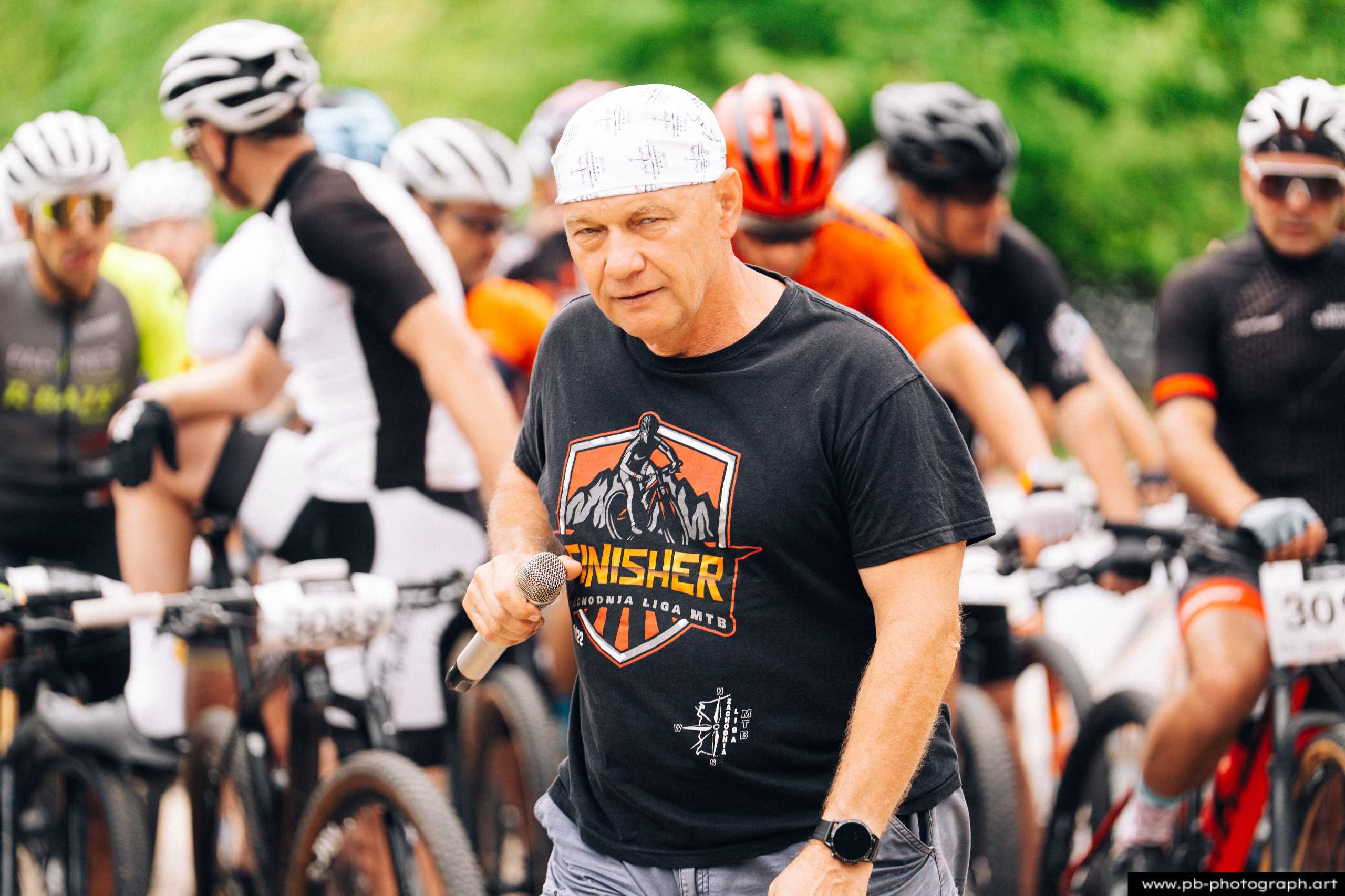 Fotografia z drona podczas Rajdu MTD w Szczecinie — organizator wyścigu MTB z mikrofonem przed zawodnikami.