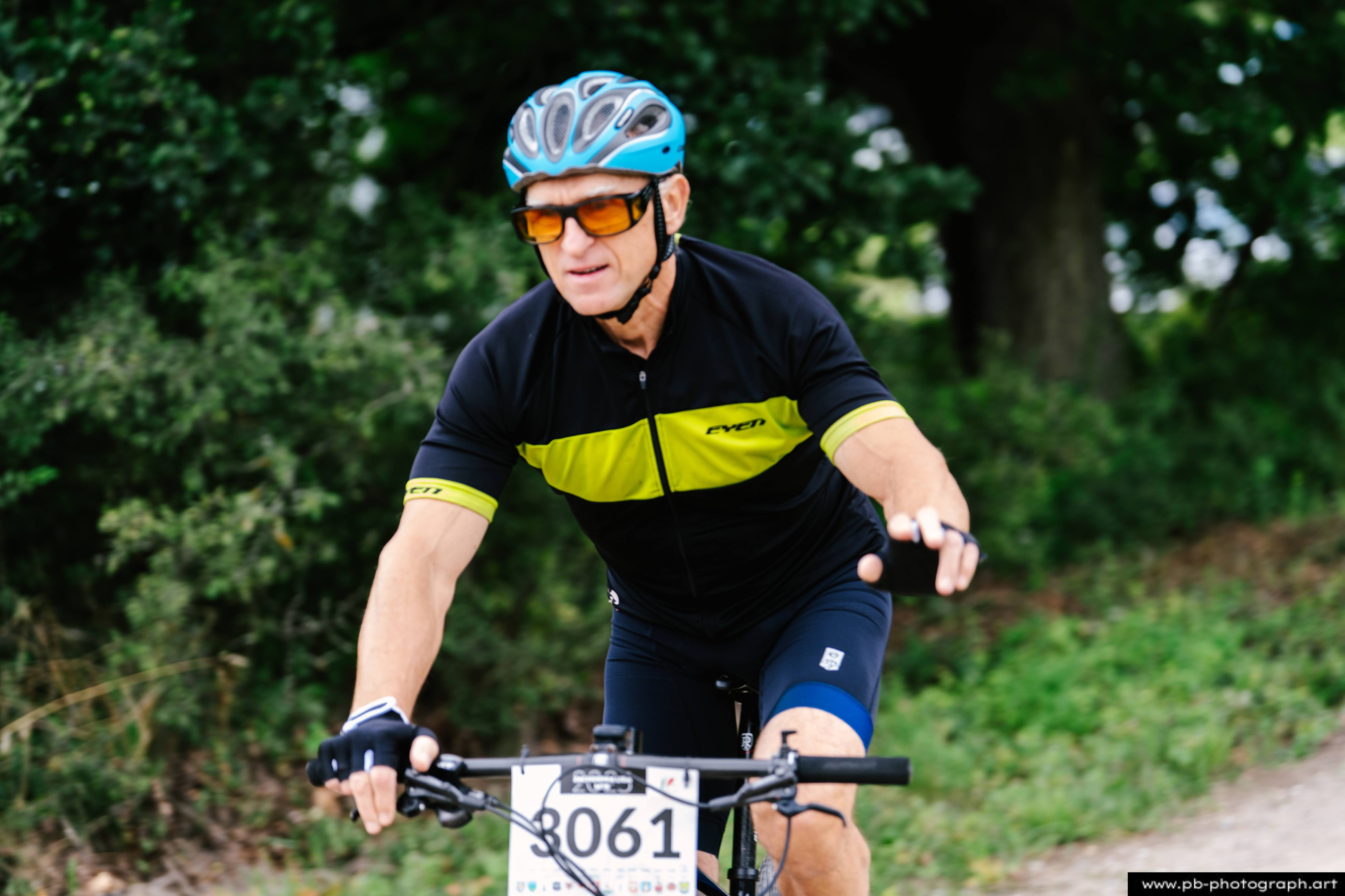 Zawodnik MTB w akcji podczas Rajdu MTD w Szczecinie, zbliżenie na kolarza w kasku i okularach przeciwsłonecznych.