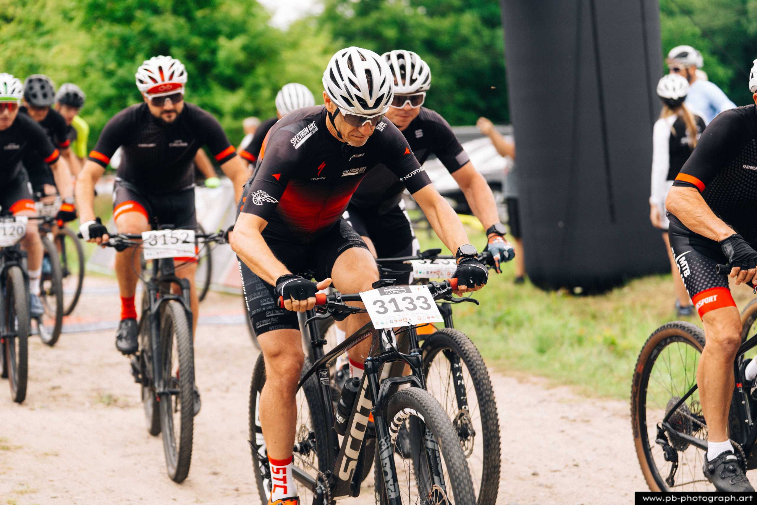 Ujęcie z drona zawodników MTB startujących w wyścigu w Szczecinie, wśród zieleni i naturalnego krajobrazu.
