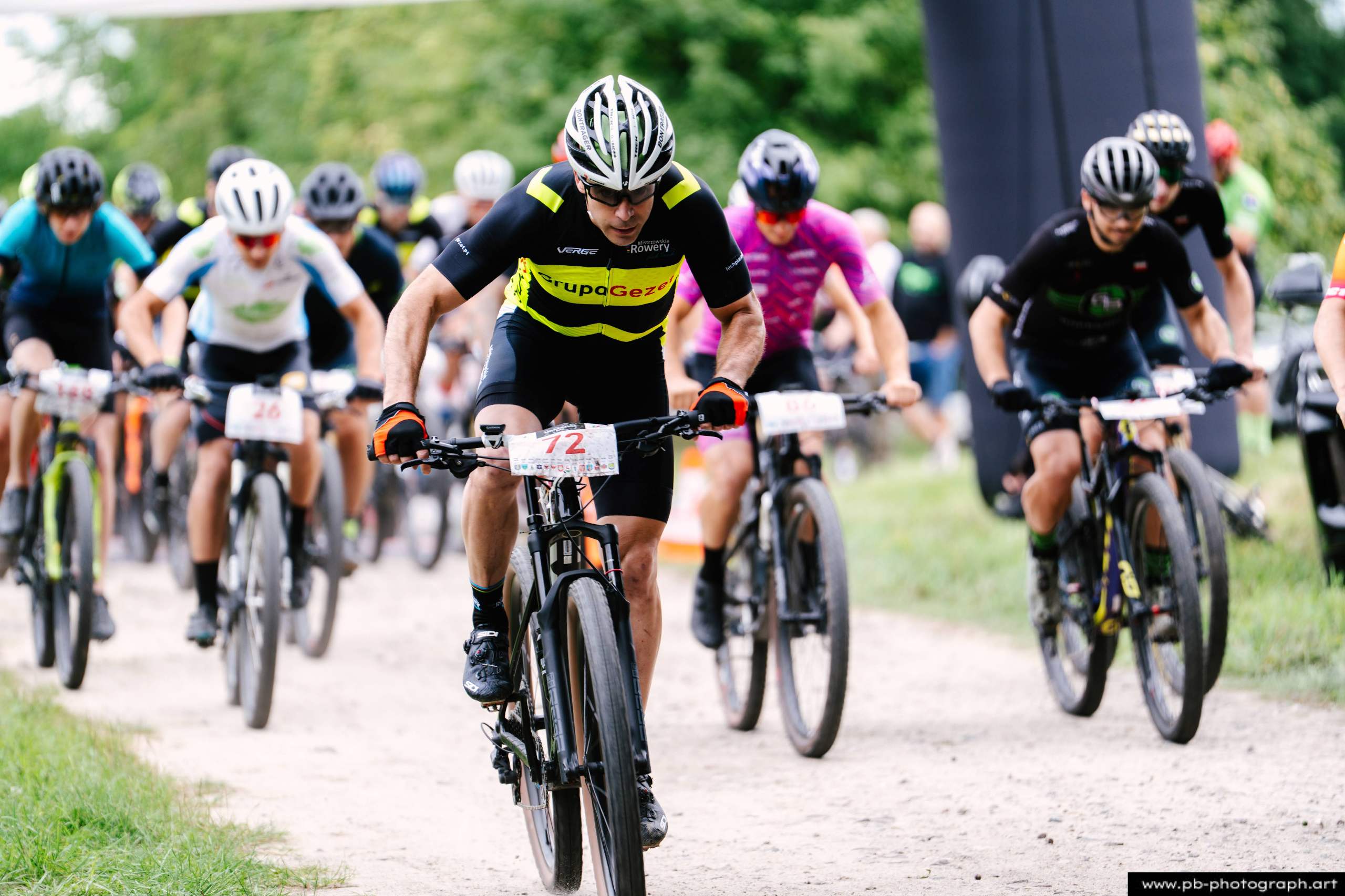 Ujęcie z drona z wyścigów MTB w Szczecinie — zawodnicy na trasie, zbliżenie na lidera wyścigu.