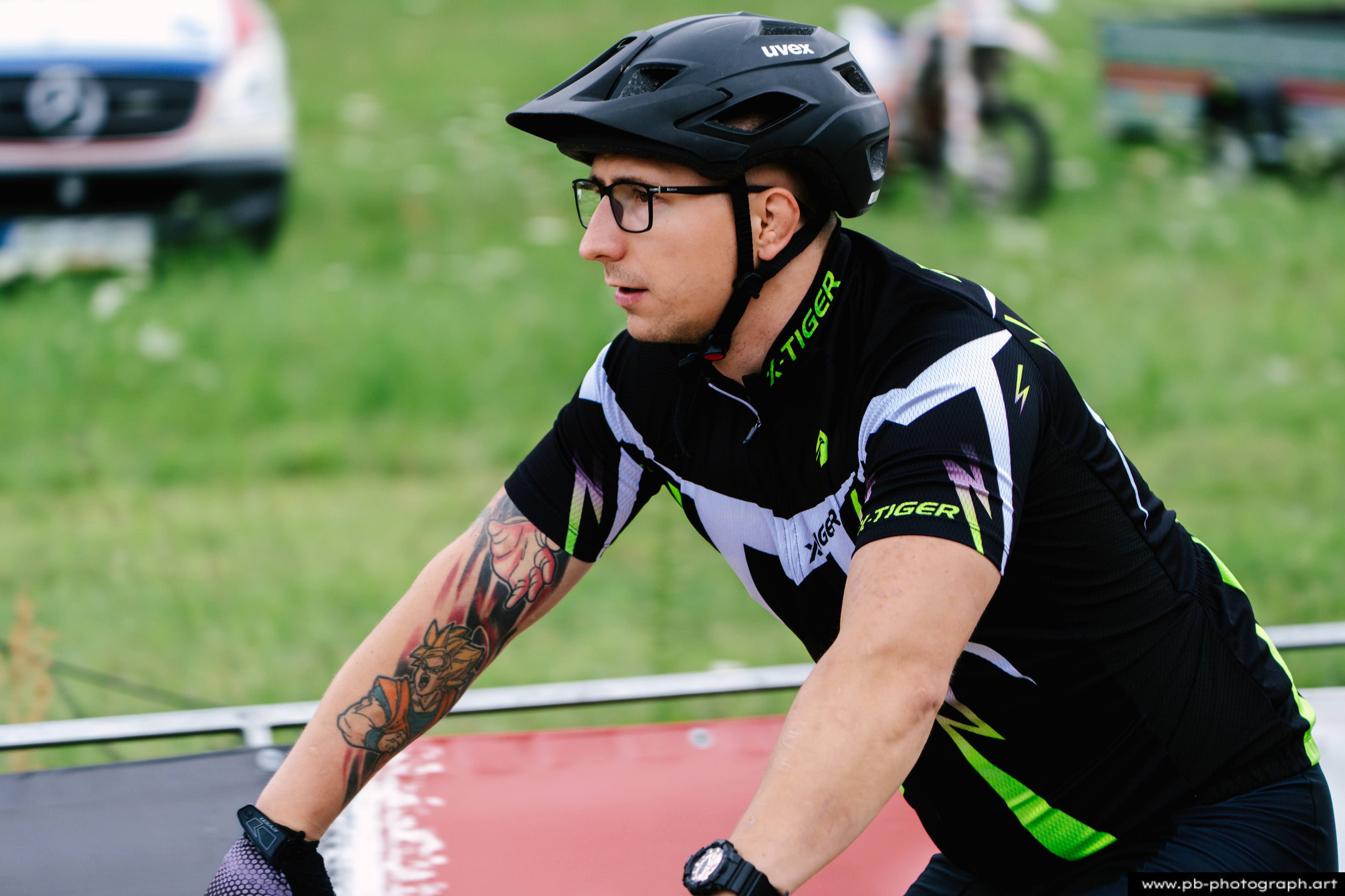 Zawodnik na rowerze górskim w kasku, przygotowujący się do wyścigu MTB w Szczecinie.