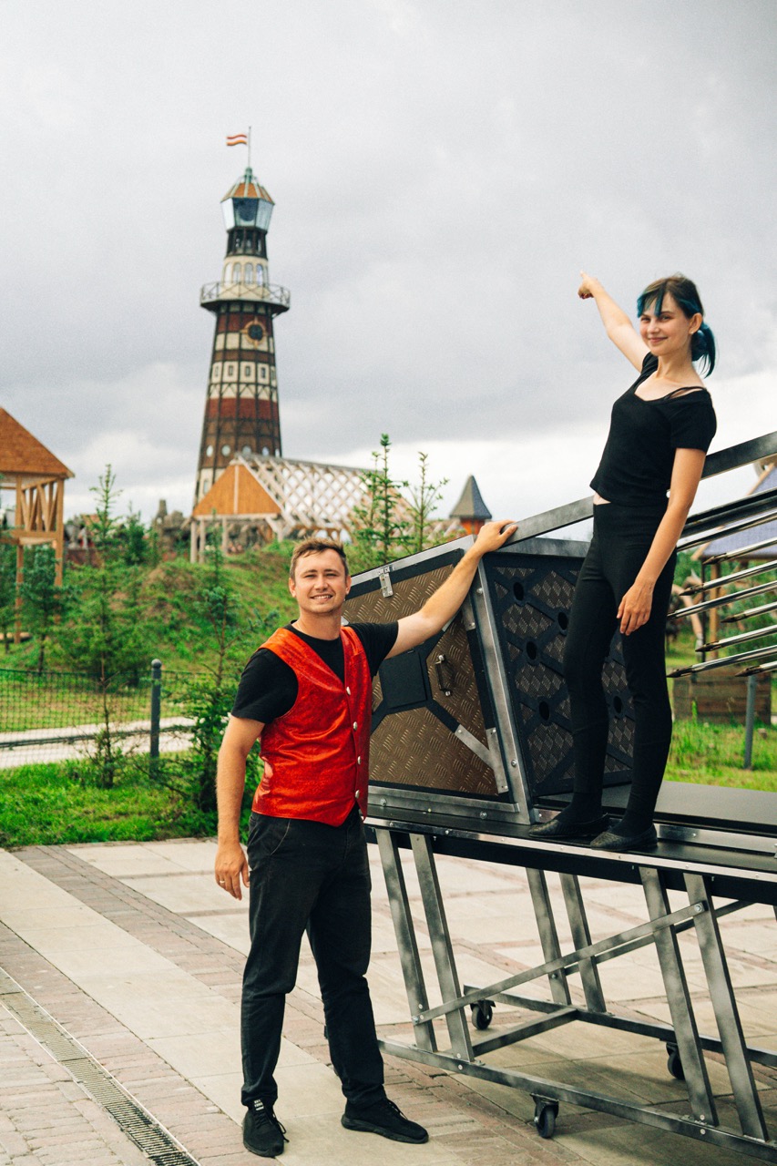 Fotografia eventowa z pokazu iluzjonisty w Szczecinie — iluzjonista i jego asystentka przy scenie z wieżą w tle.
