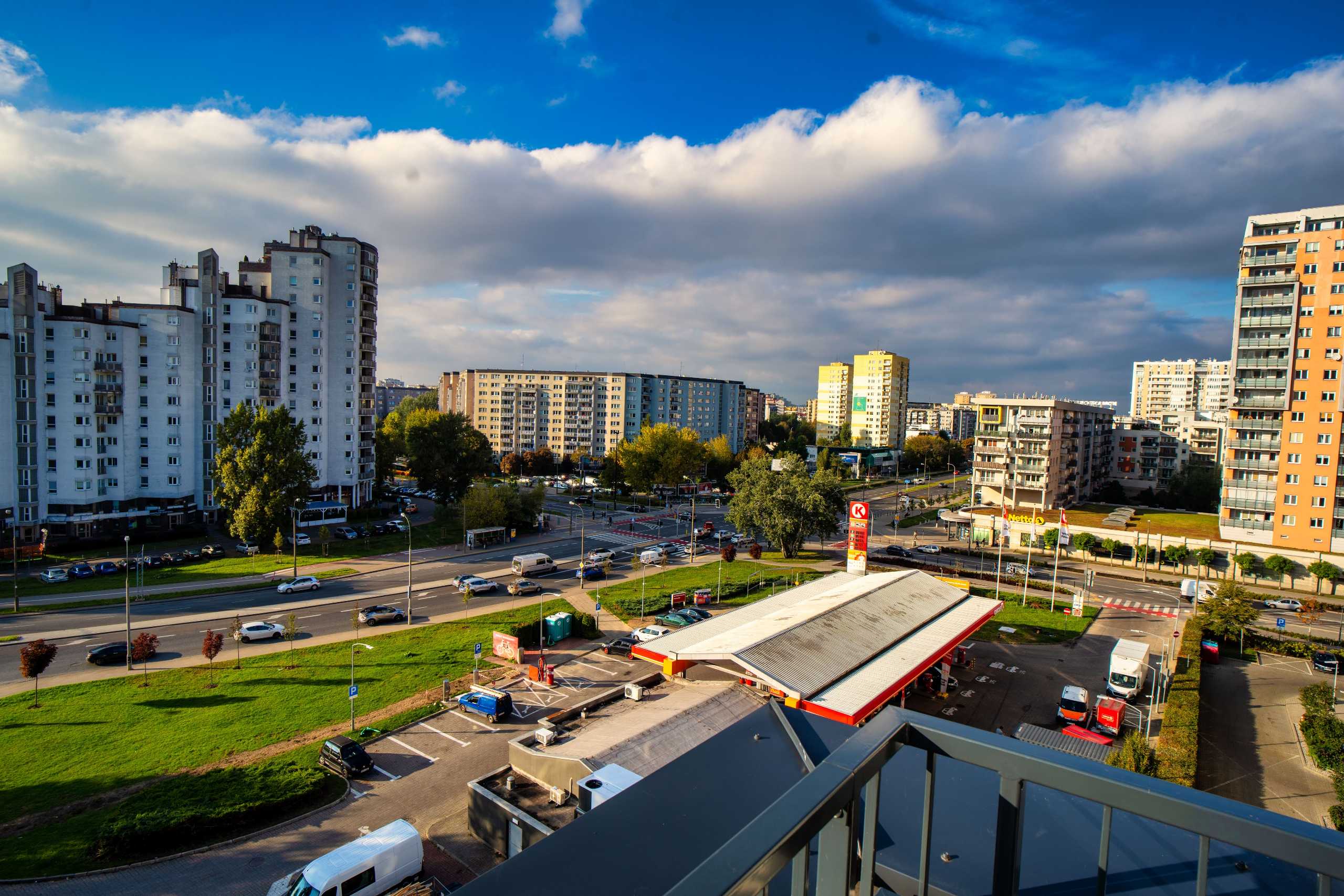 Widok z okna apartamentu w Warszawie, ukazujący panoramę miasta z nowoczesnymi budynkami i ulicami.