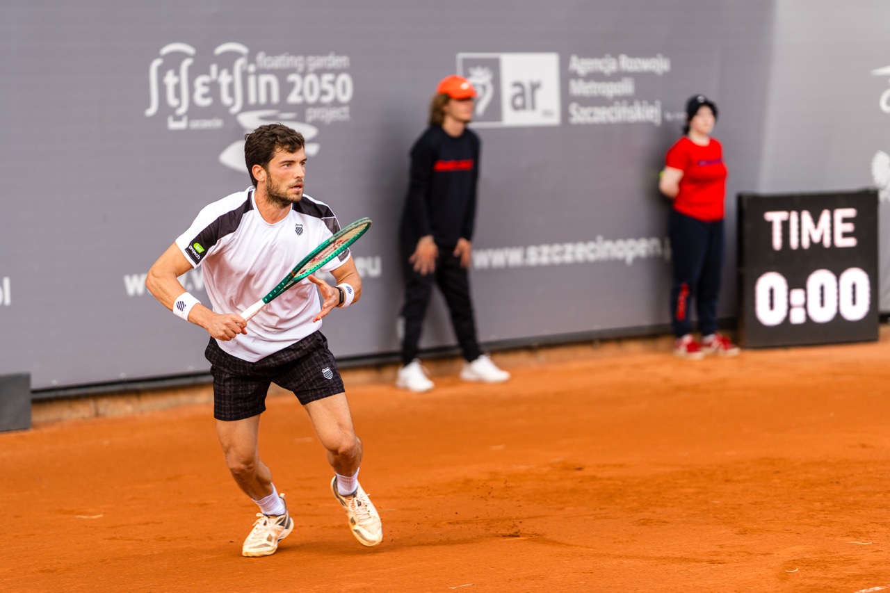 Zawodnik w trakcie akcji na korcie tenisowym podczas Invest in Szczecin Open 2026, z publicznością w tle.
