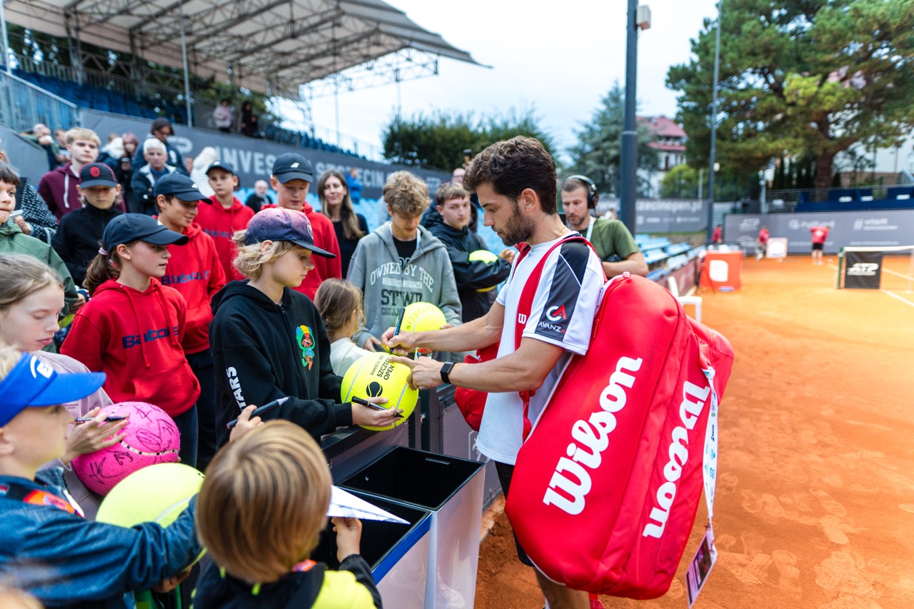 Zawodnik tenisa podpisuje piłki dla fanów po meczu na turnieju Invest in Szczecin Open 2026.