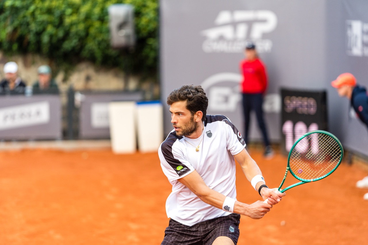 Zawodnik w akcji podczas meczu na korcie, dynamicznie wykonujący forehand na turnieju tenisowym w Szczecinie.