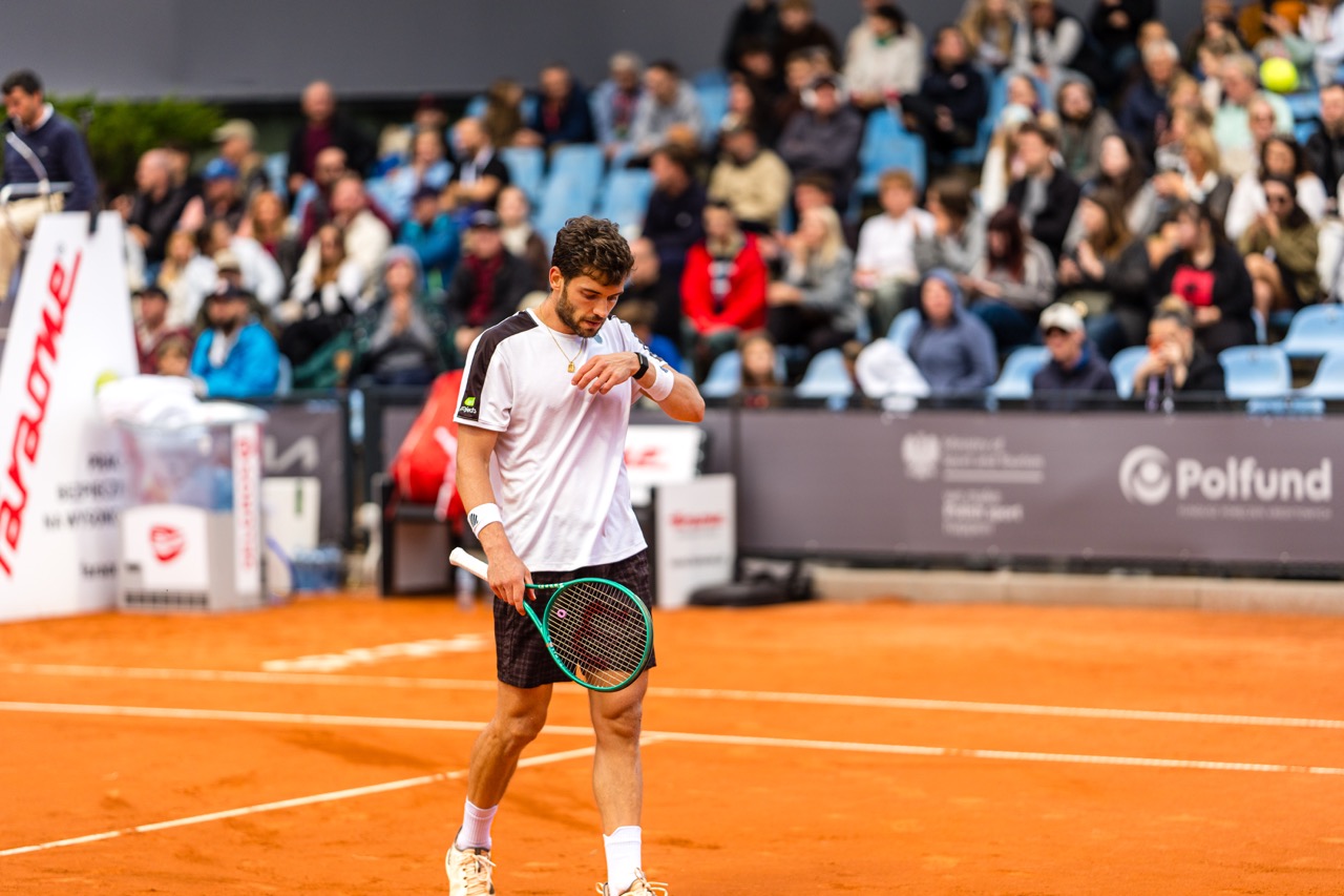 Zawodnik tenisa na korcie podczas turnieju Invest in Szczecin Open 2026, z emocjami na twarzy i publicznością w tle.