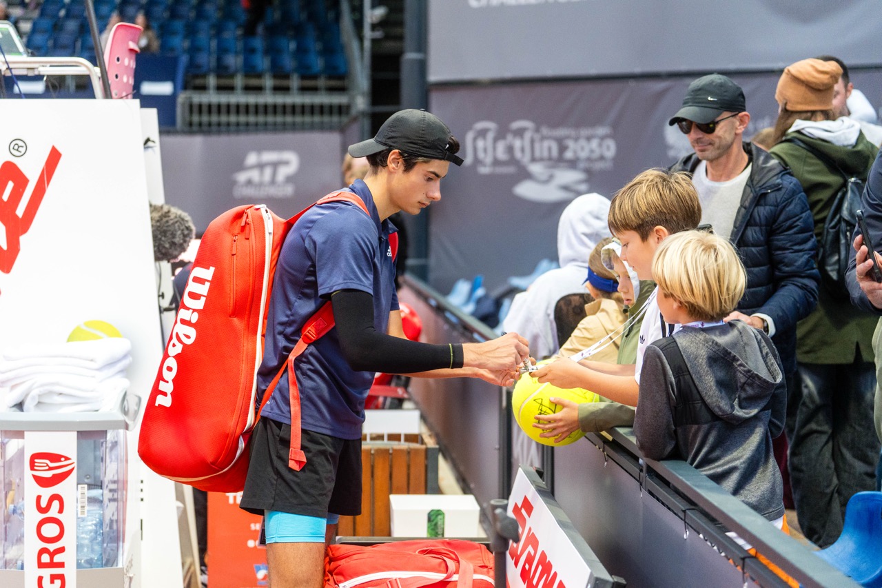 Zawodnik tenisa podpisuje piłki dla młodych fanów podczas turnieju Invest in Szczecin Open 2026.