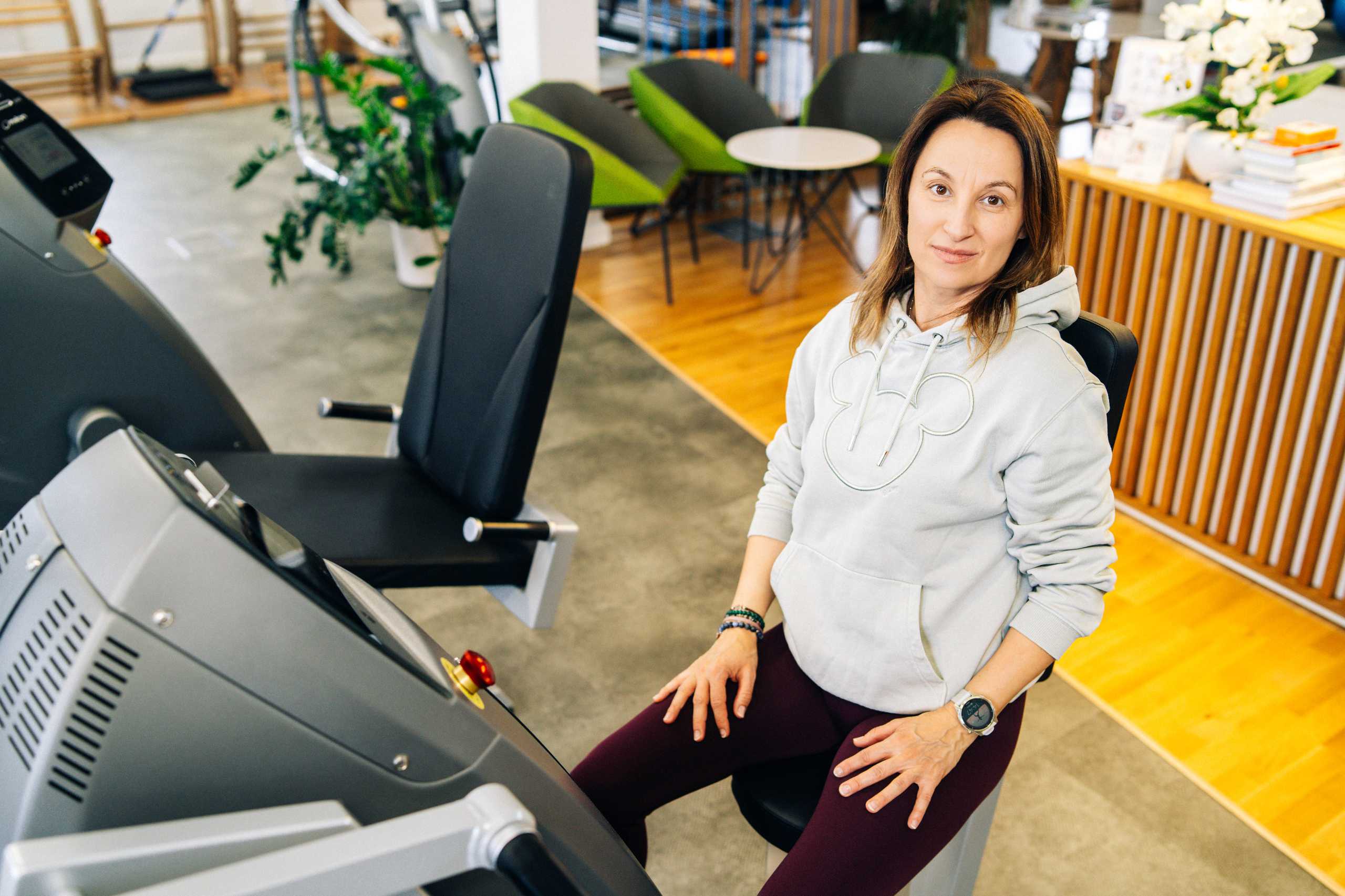 Trenerka w Klubie Fitnes 3L w Mierzynie podczas sesji wizerunkowej, siedząca na sprzęcie do ćwiczeń.