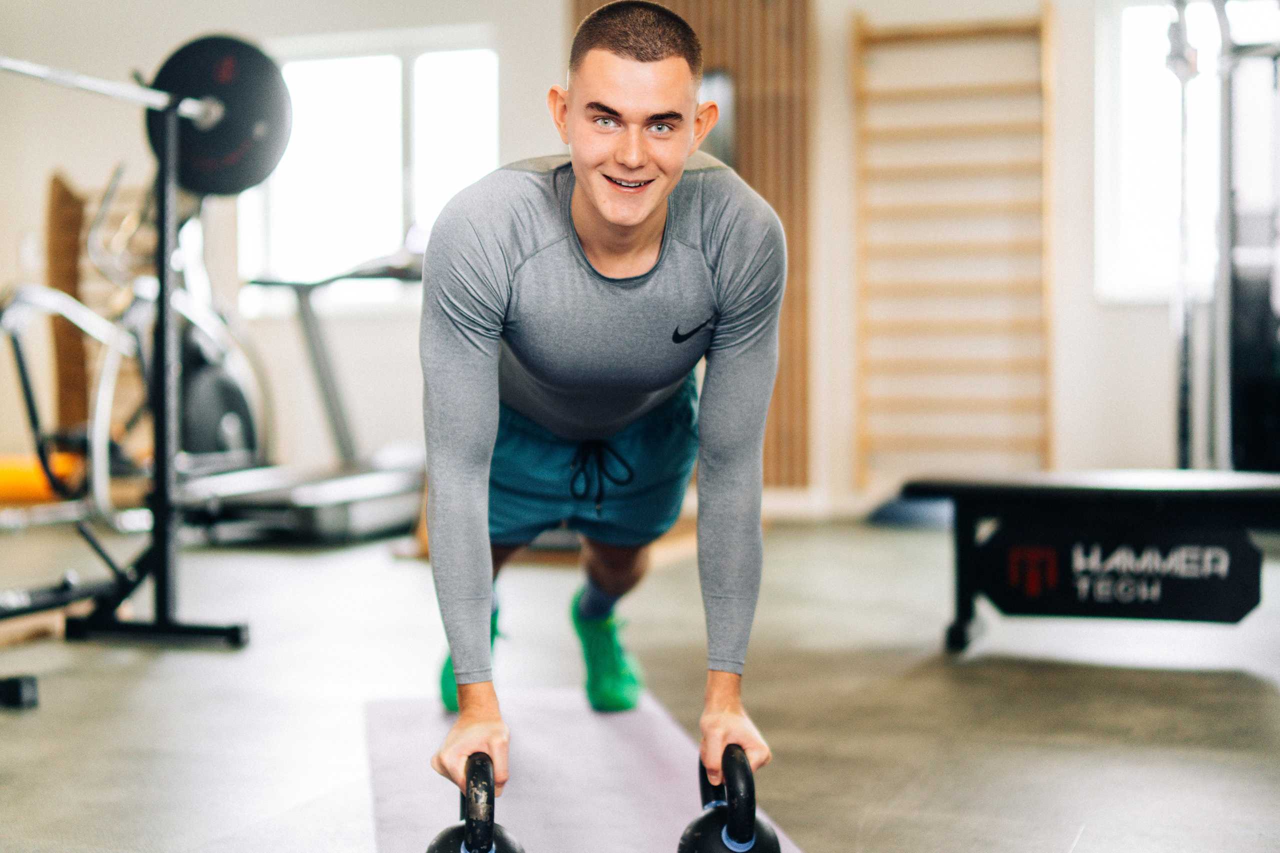 Trener w akcji podczas ćwiczeń z kettlebell w Klubie Fitnes 3L w Mierzynie, Szczecin.