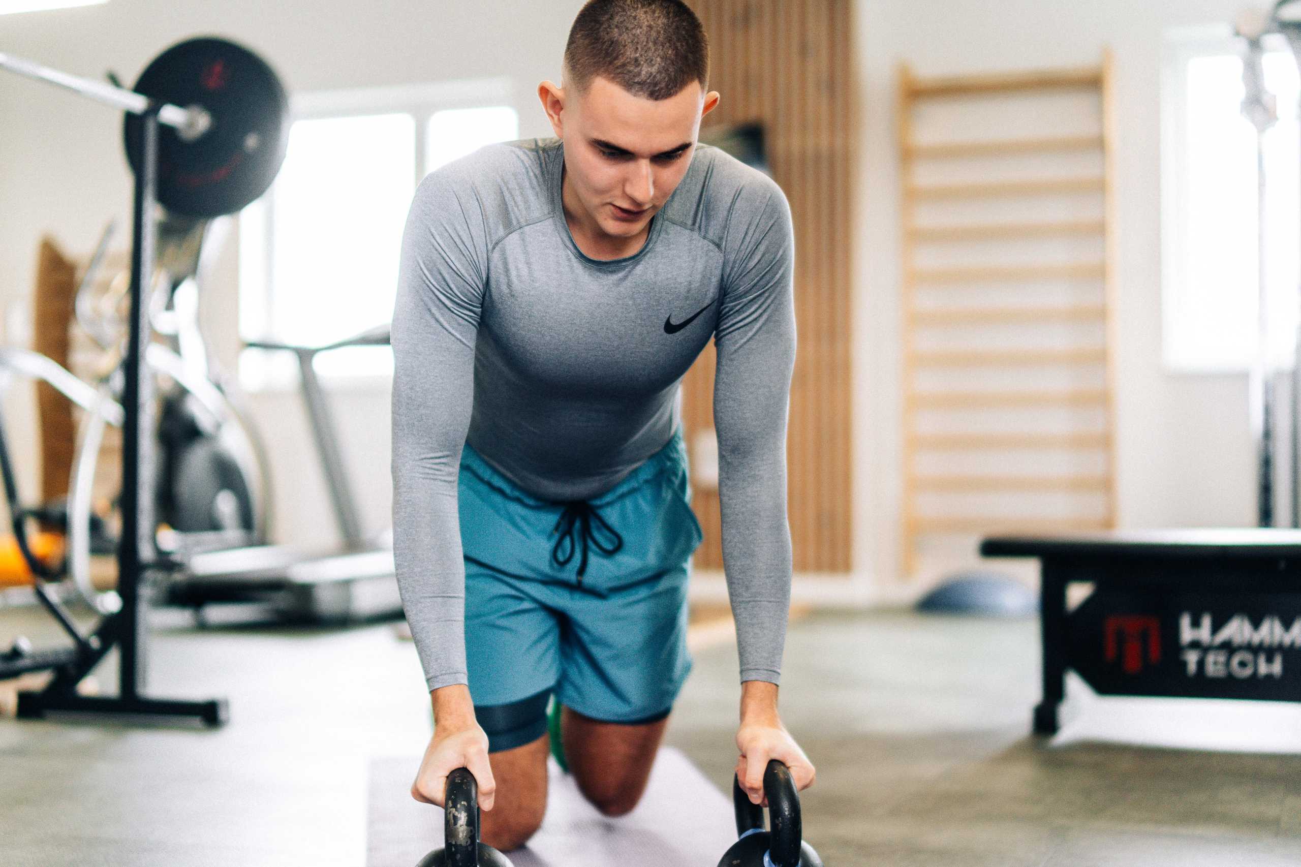 Fotografia wizerunkowa — trener wykonujący ćwiczenia z kettlebell w Klubie Fitnes 3L w Mierzynie.