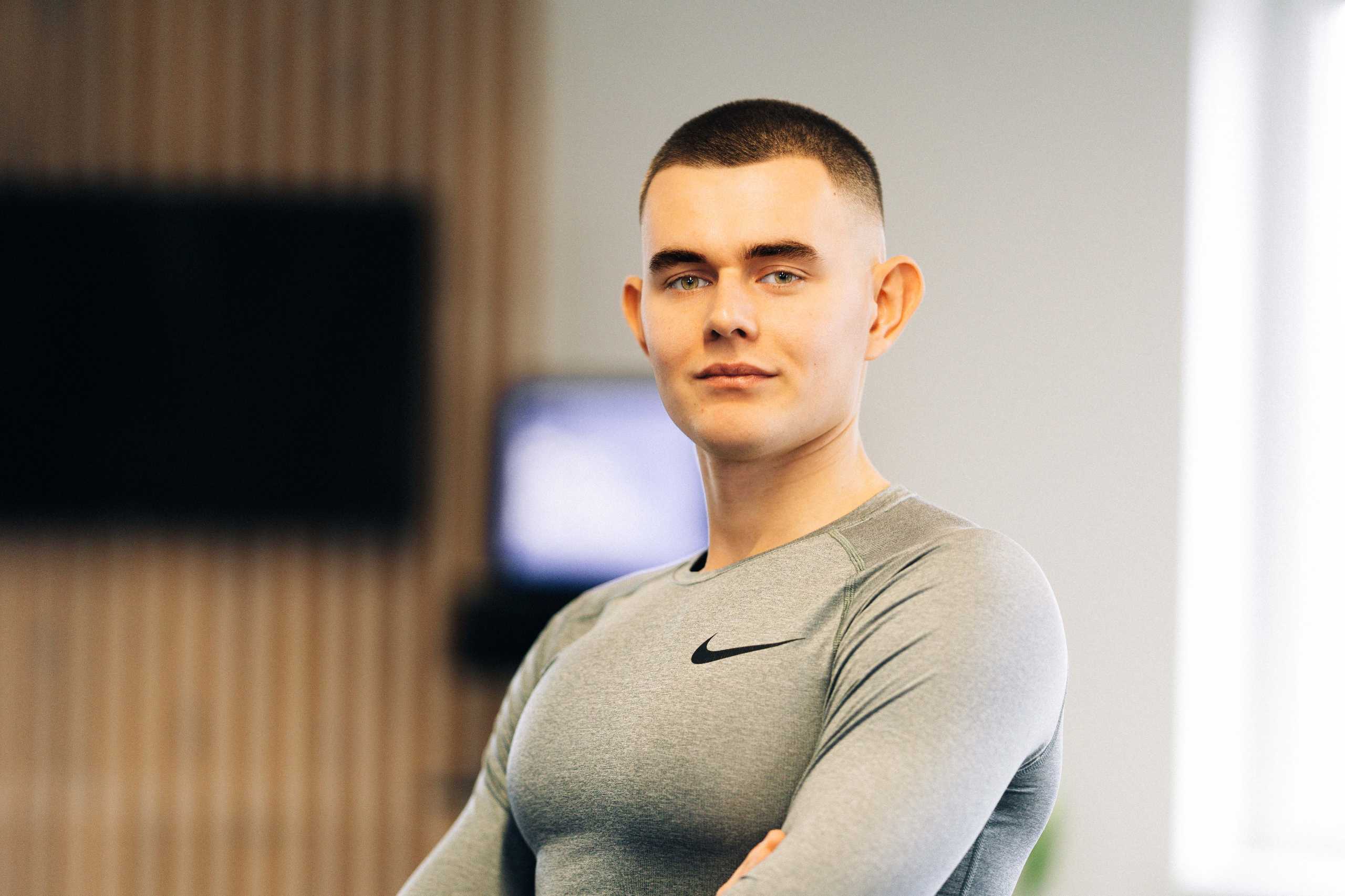 Portret trenera w Klubie Fitnes 3L w Mierzynie, podkreślający profesjonalizm i zaangażowanie w pracy z klientami.