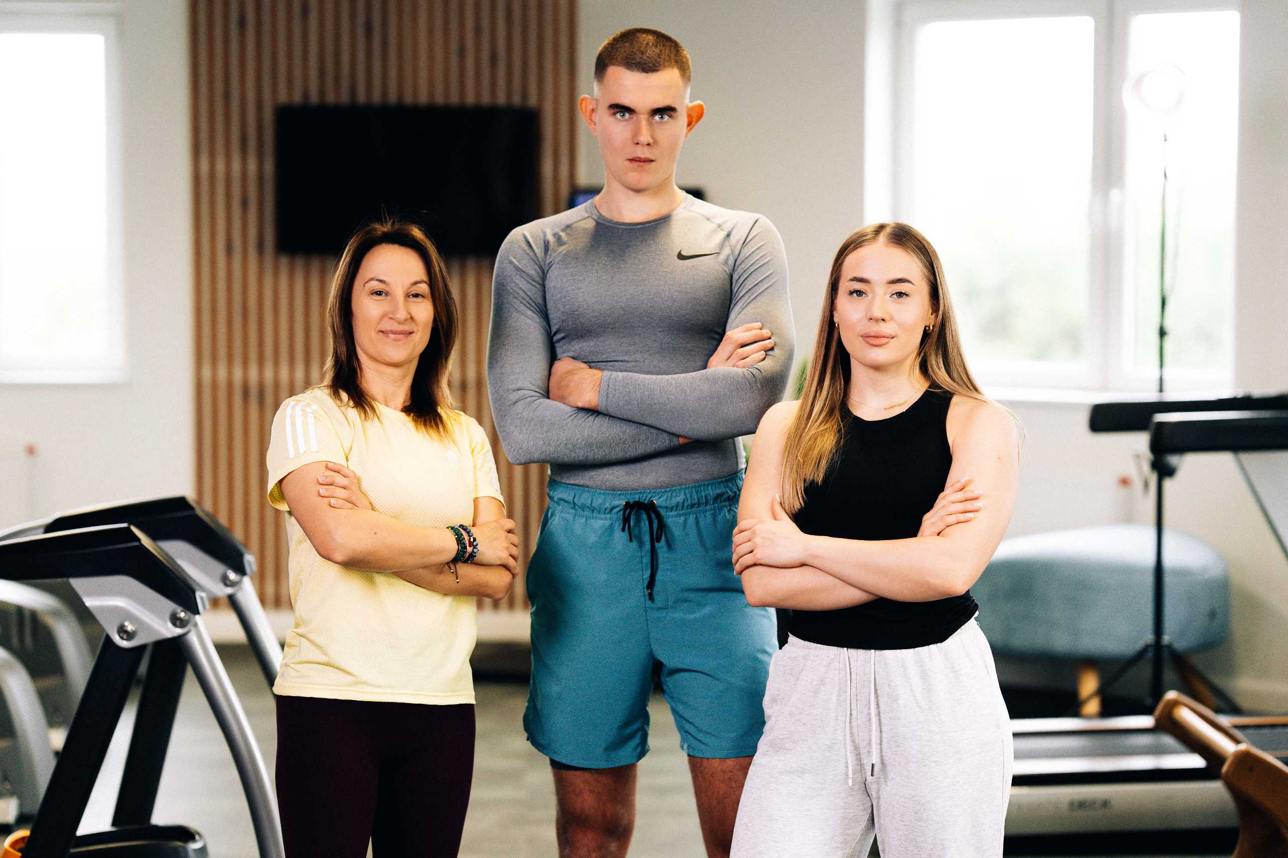 Fotografia wizerunkowa zespołu trenerów w Klubie Fitnes 3L w Mierzynie, z uśmiechami i pewnością siebie.