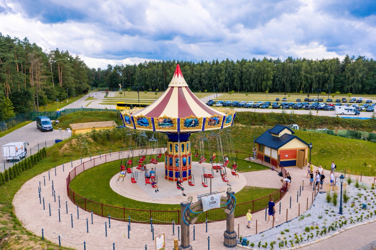 Ujęcie z drona parku rozrywki Hossoland w Szczecinie — karuzela w akcji z gośćmi i otoczeniem.