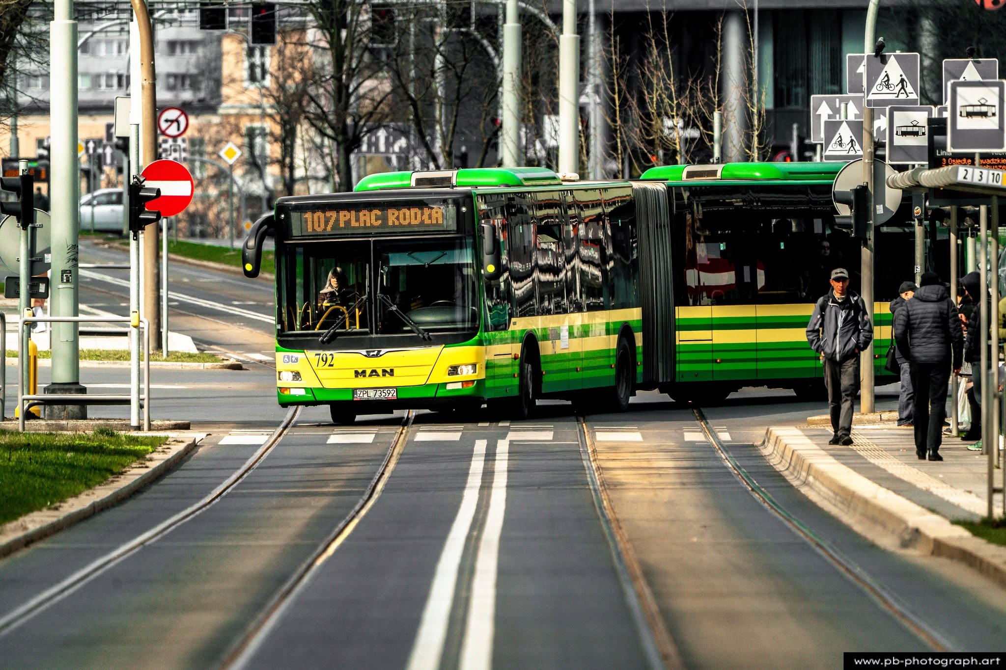 Fotografia uliczna w Szczecinie — autobus komunikacji miejskiej na przystanku w ruchliwej części miasta.