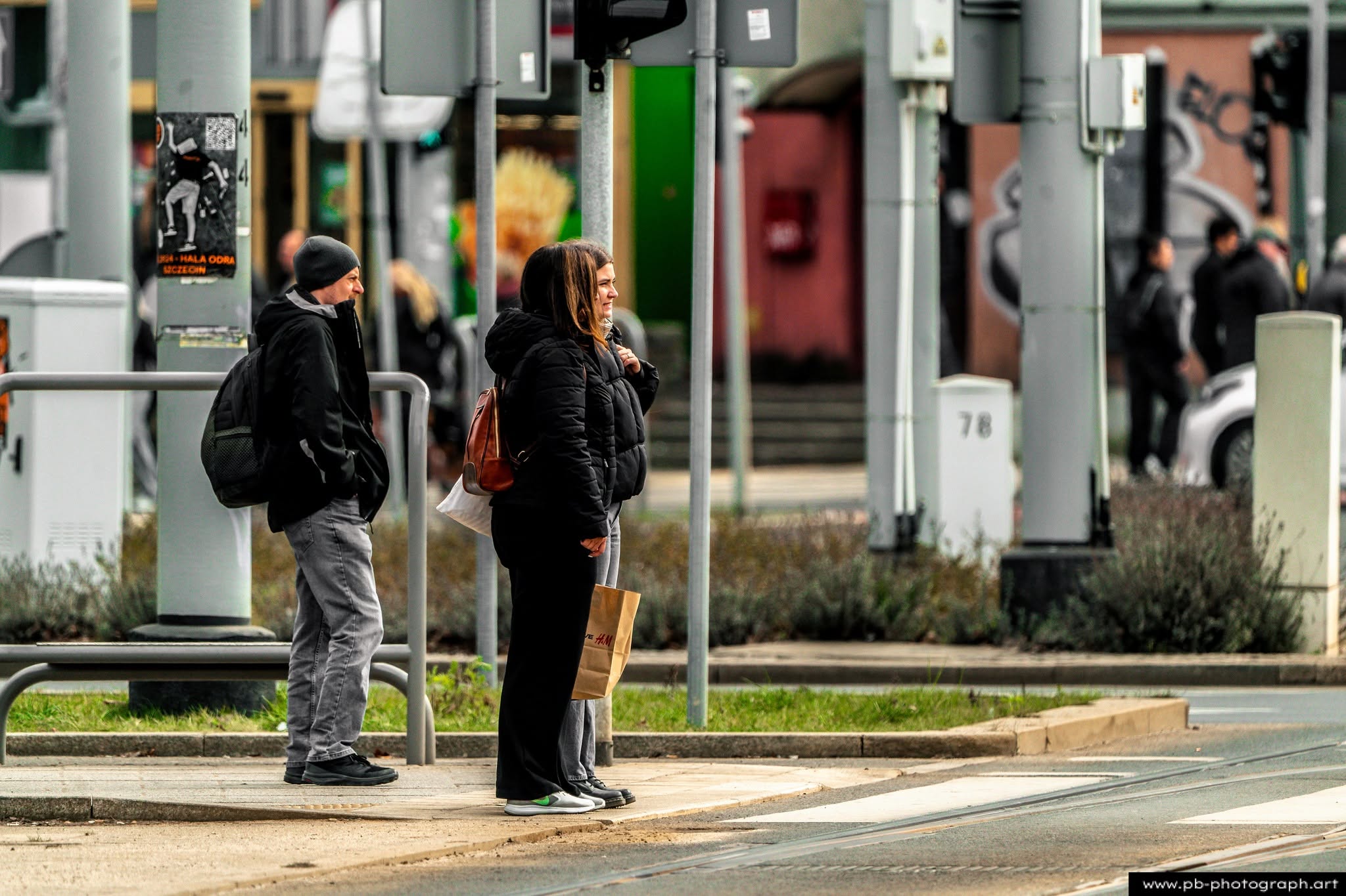 Ujęcie z życia miejskiego w Szczecinie — pasażerowie czekający na przystanku tramwajowym.